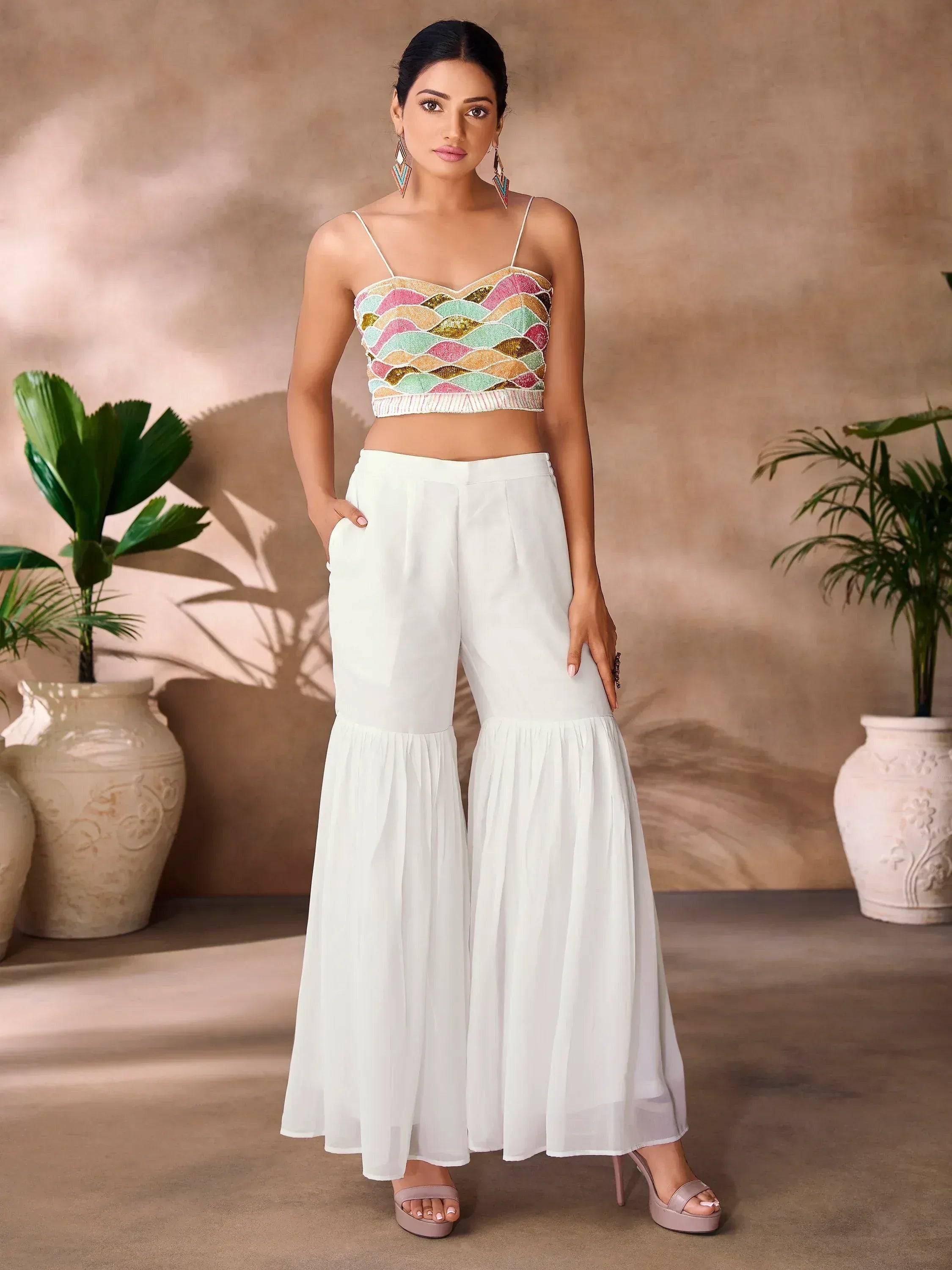 Woman in colorful sequin crop top and white flared palazzo pants, ethnic wear outfit