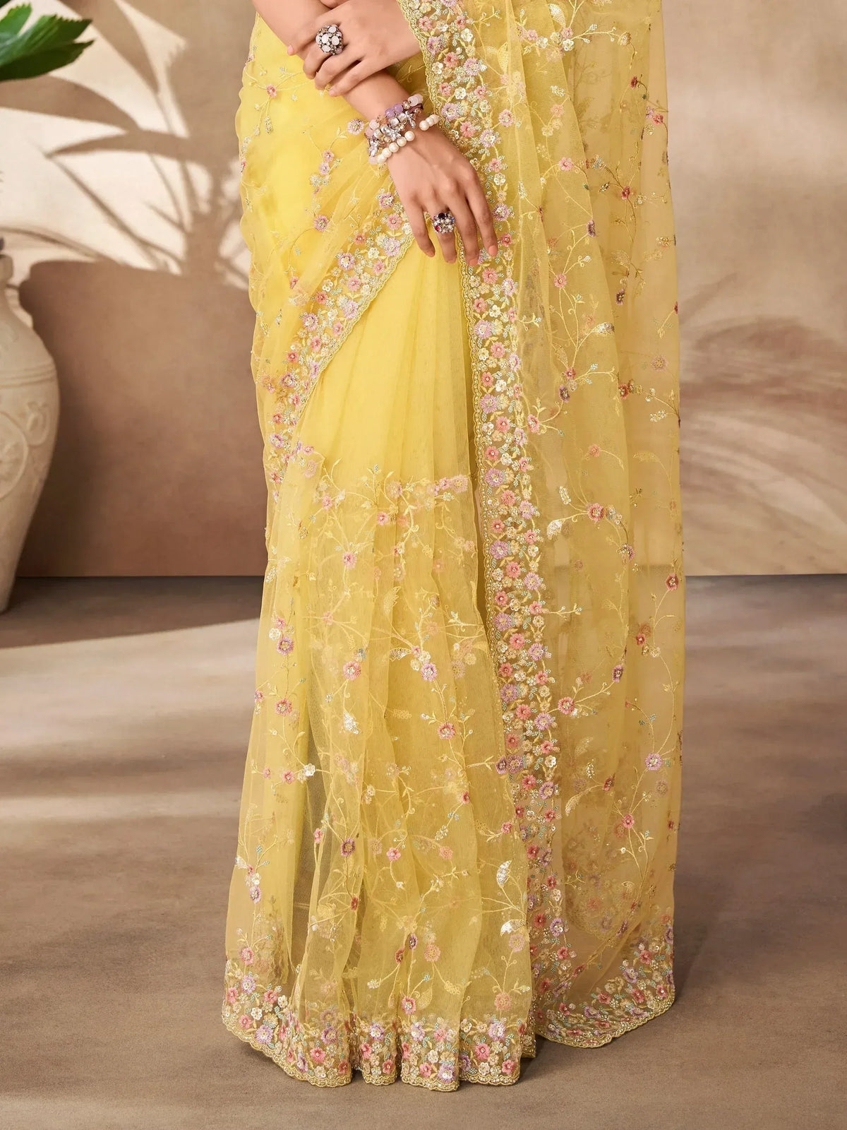 Yellow floral embroidered saree with delicate pink and gold detailing, perfect for ethnic occasions