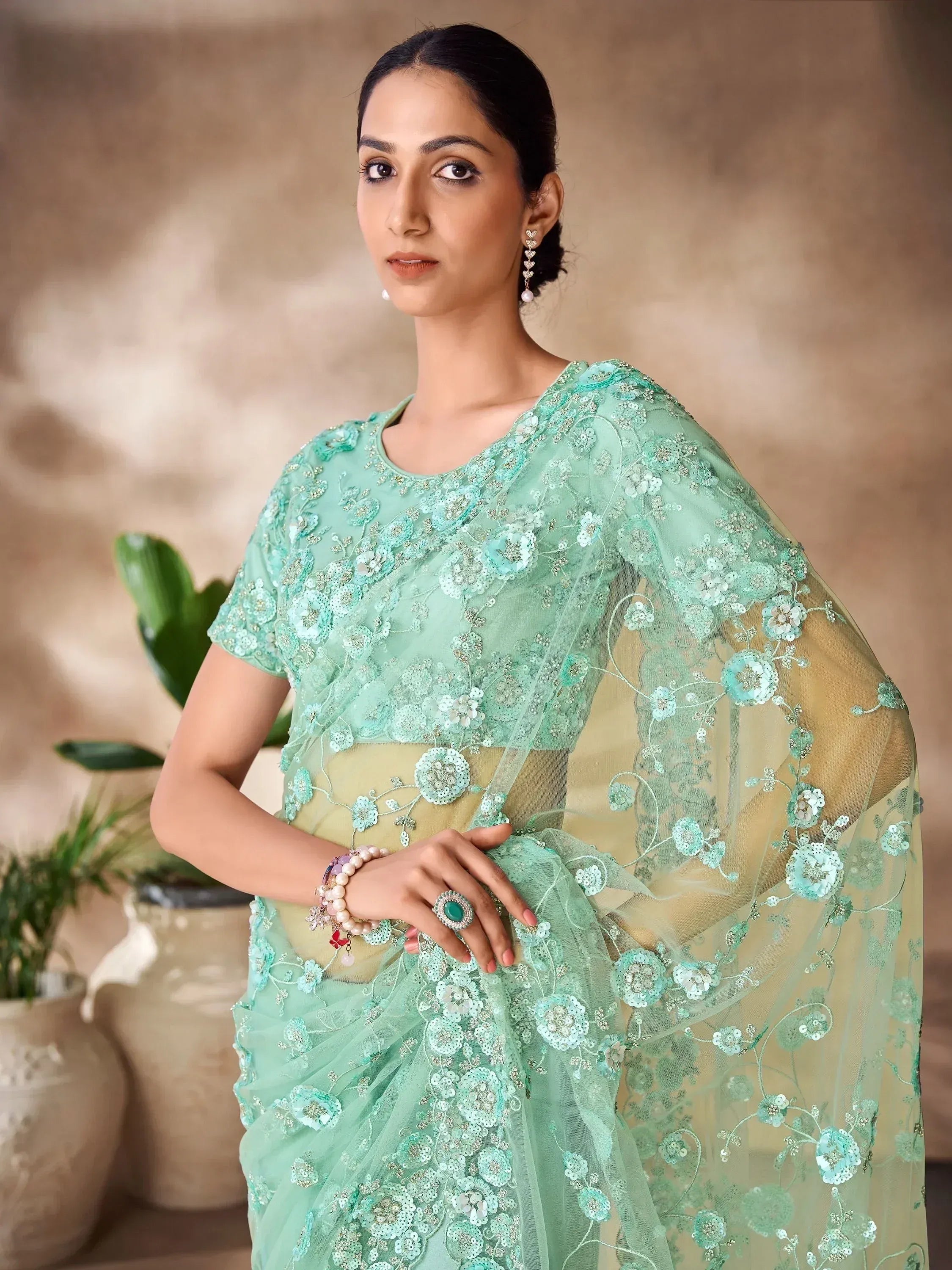 Mint green embroidered saree with floral appliqué and sheer cape, perfect for Indian ethnic wear occasions.