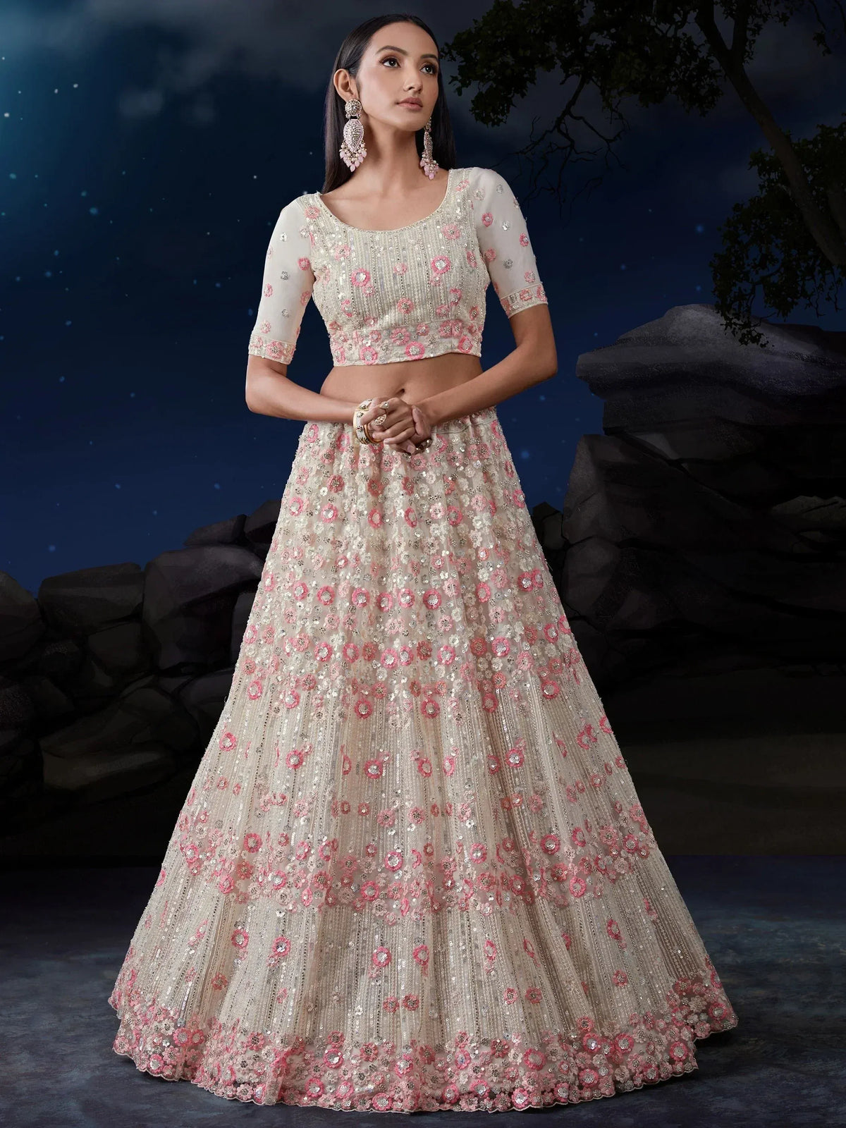 Elegant ivory lehenga choli with pink floral embroidery and sequins, perfect for Indian weddings and festive occasions.