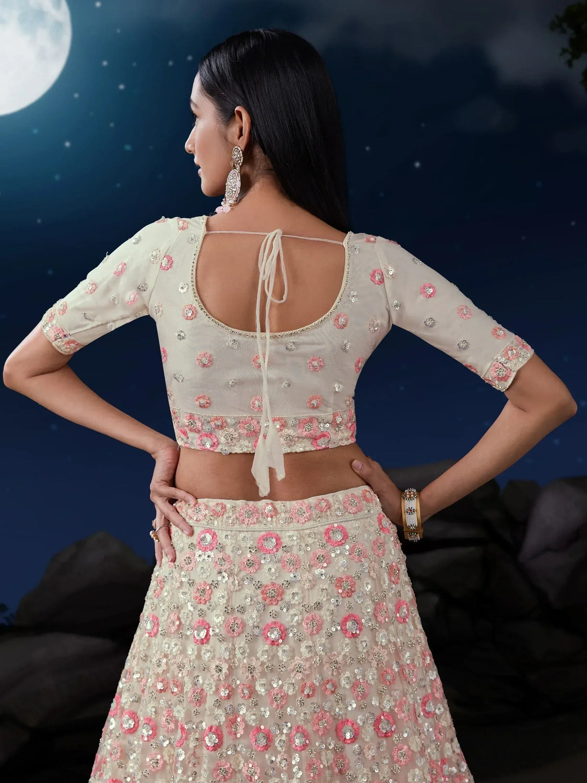 Elegant cream lehenga choli with pink floral embroidery, perfect for Indian ethnic wear events under moonlight.