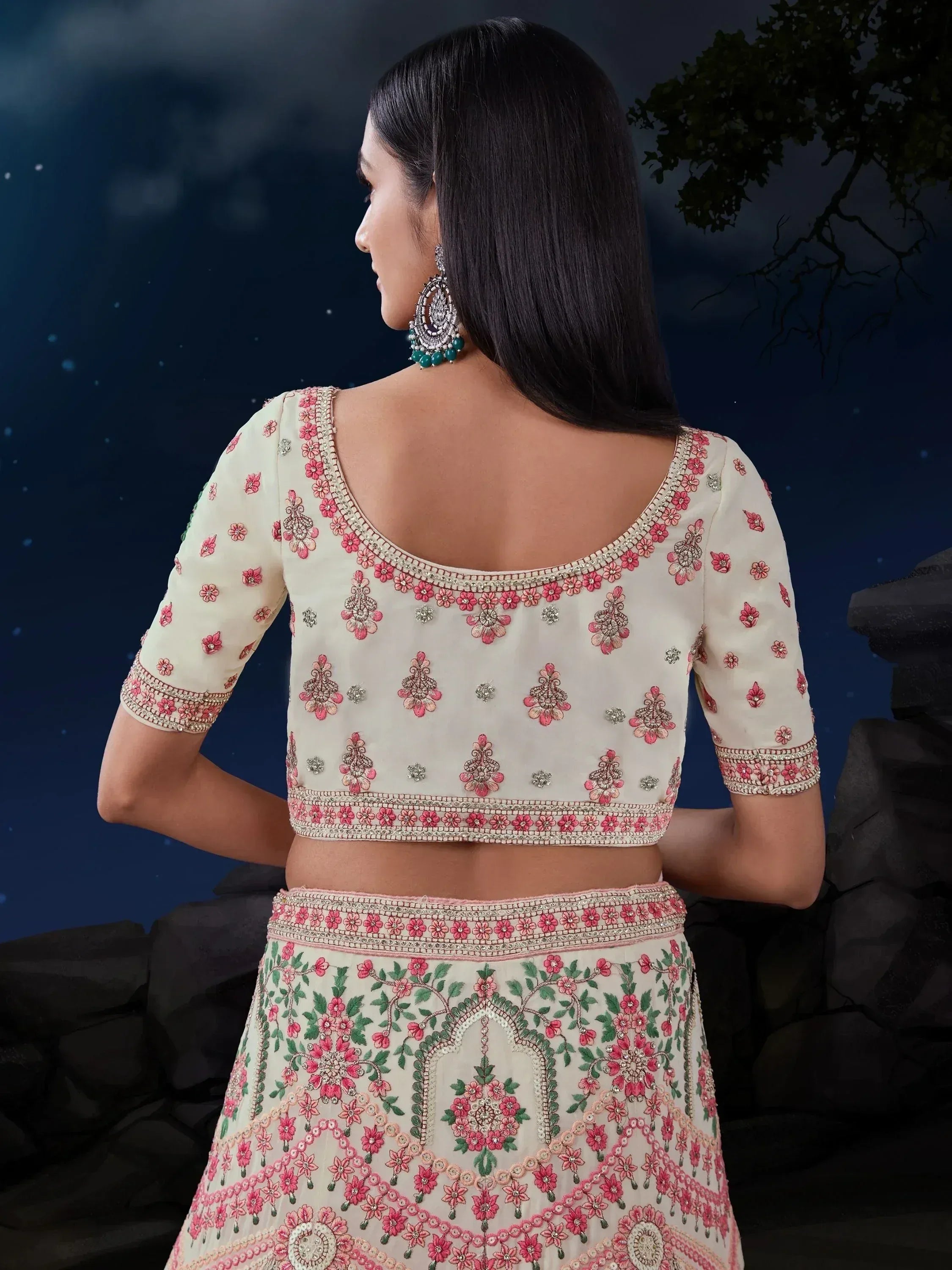 Cream lehenga choli with pink floral embroidery, perfect for Indian weddings and festive occasions.