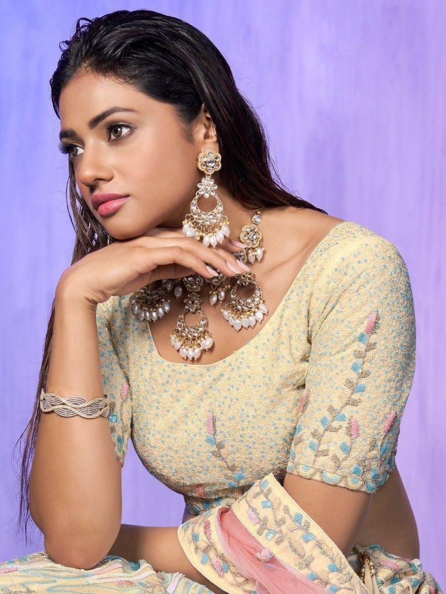 Elegant Indian ethnic wear with floral embroidery, pearl jewelry, and designer blouse for festive occasions