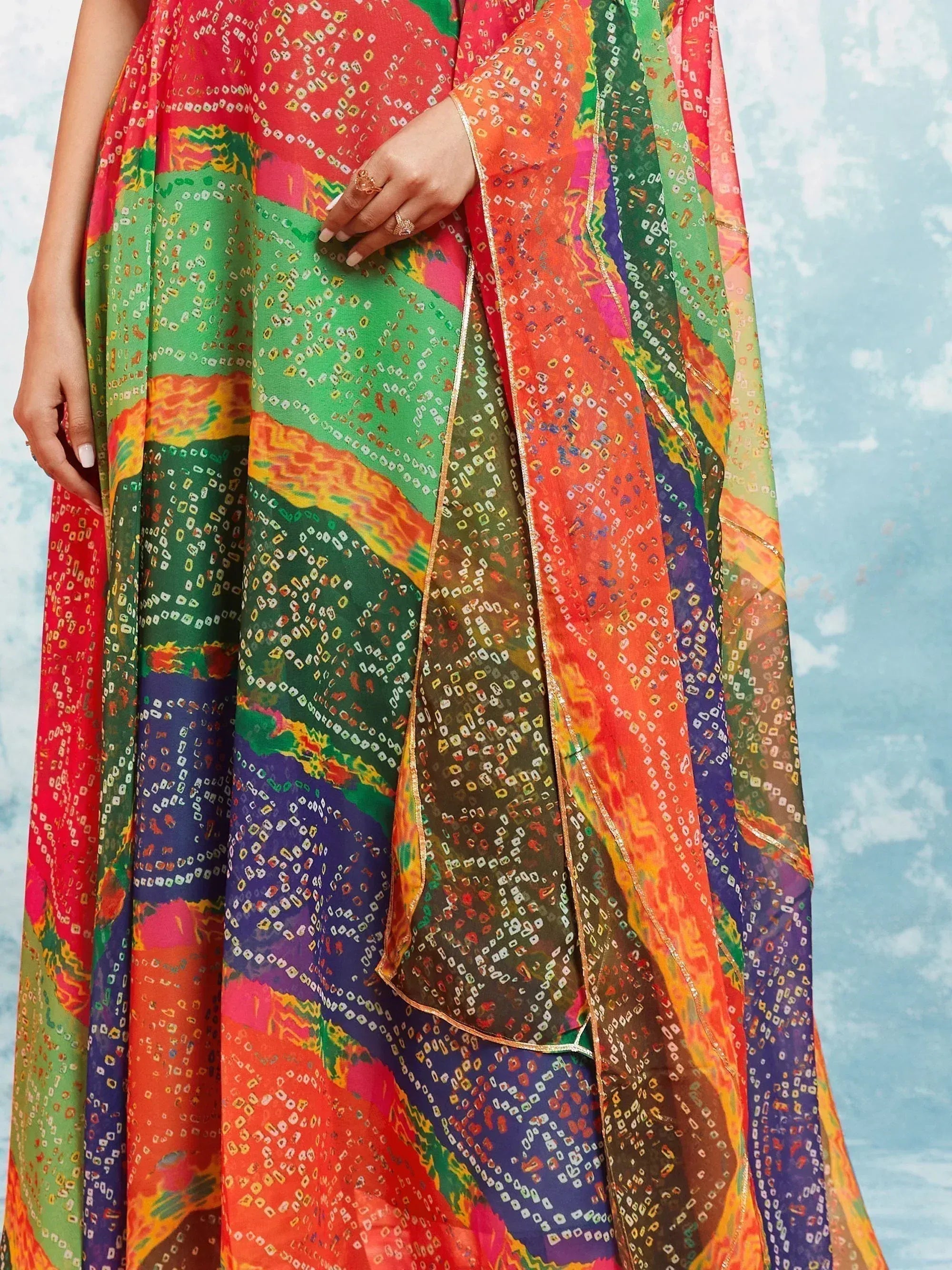 Woman wearing a colorful bandhani print saree with multicolor ethnic patterns and dupatta