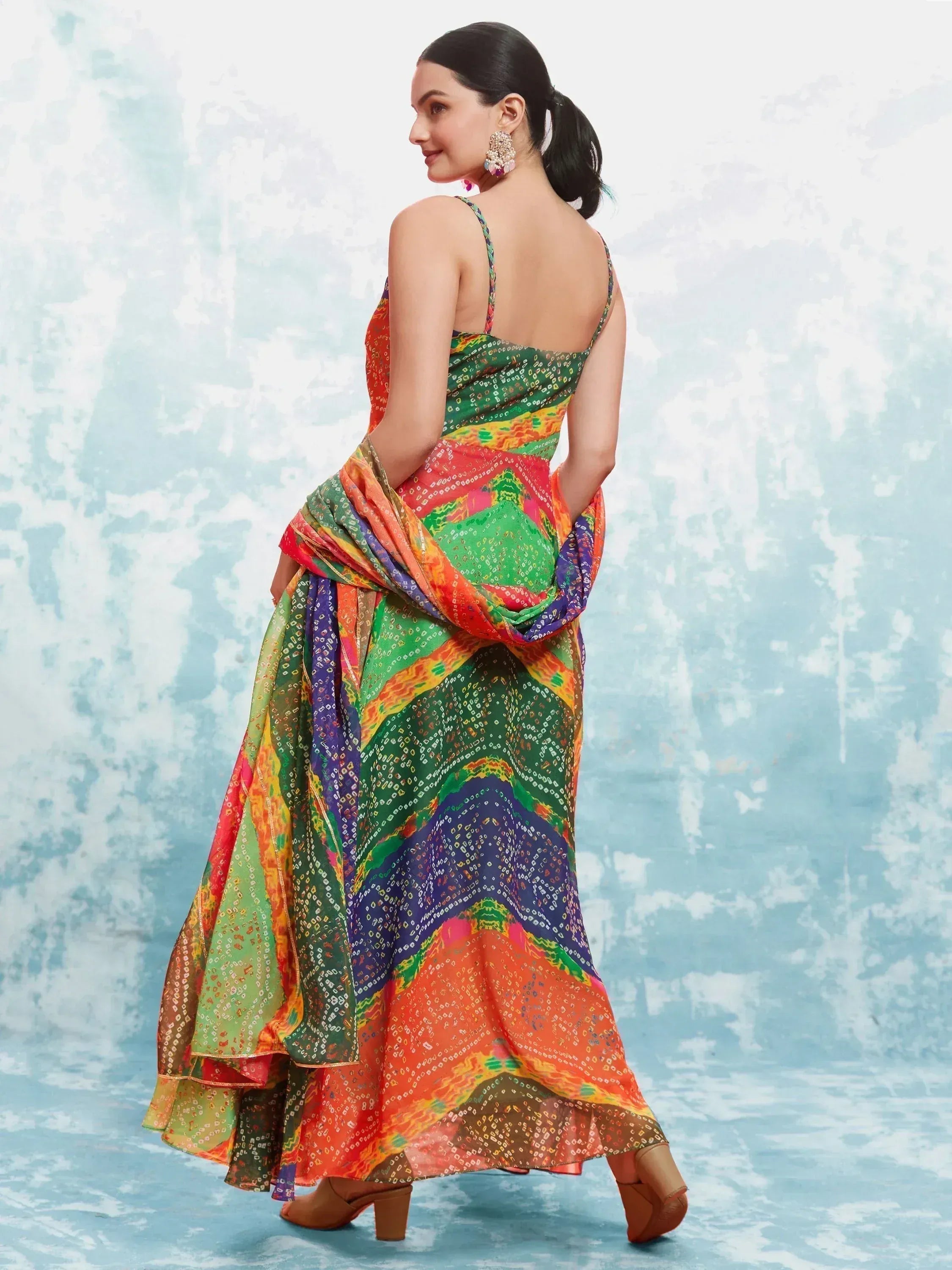 Woman in colorful bandhani printed ethnic lehenga with dupatta, traditional jewelry