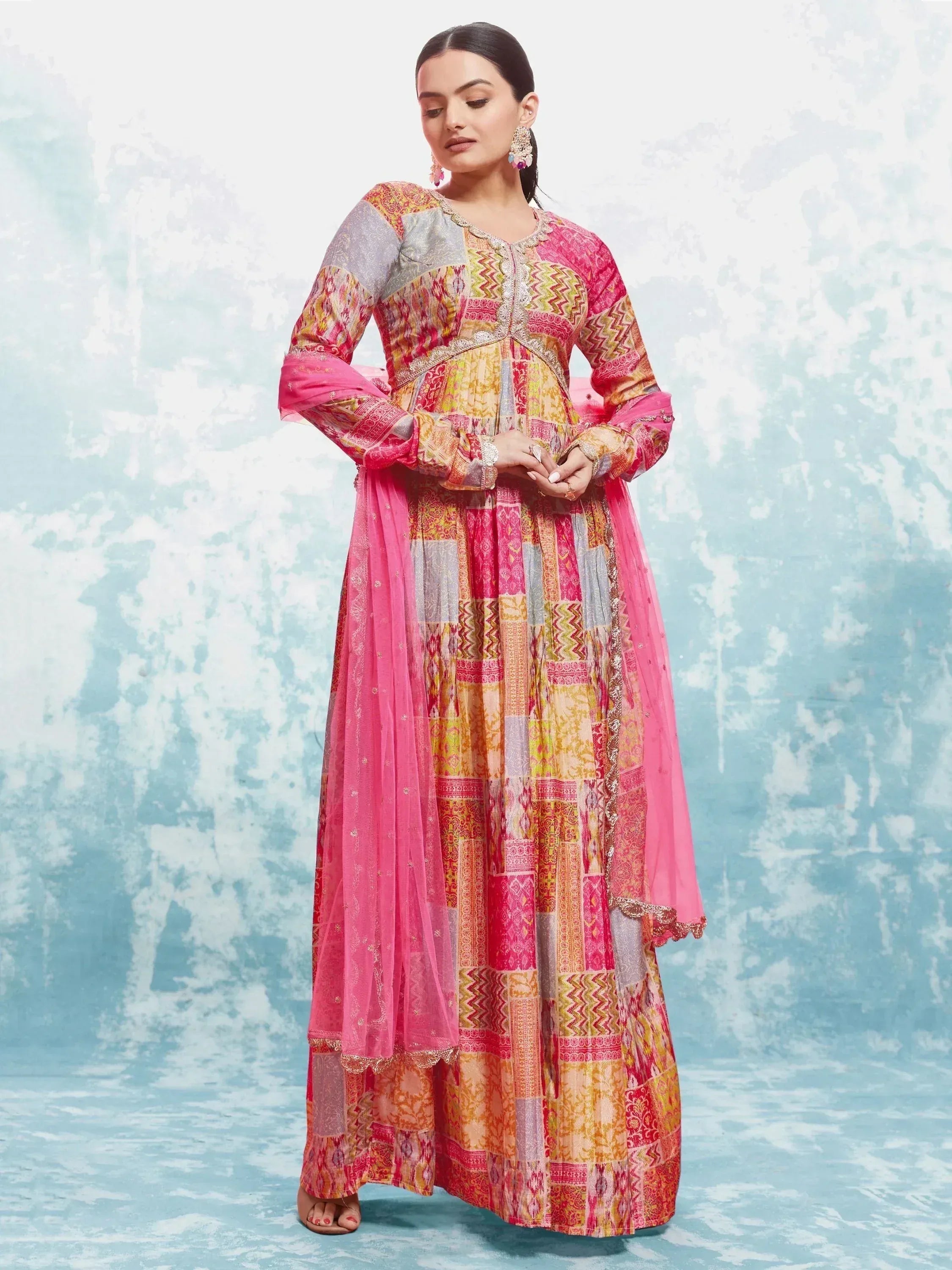 Woman wearing colorful patchwork anarkali suit with pink dupatta, Indian ethnic gown style