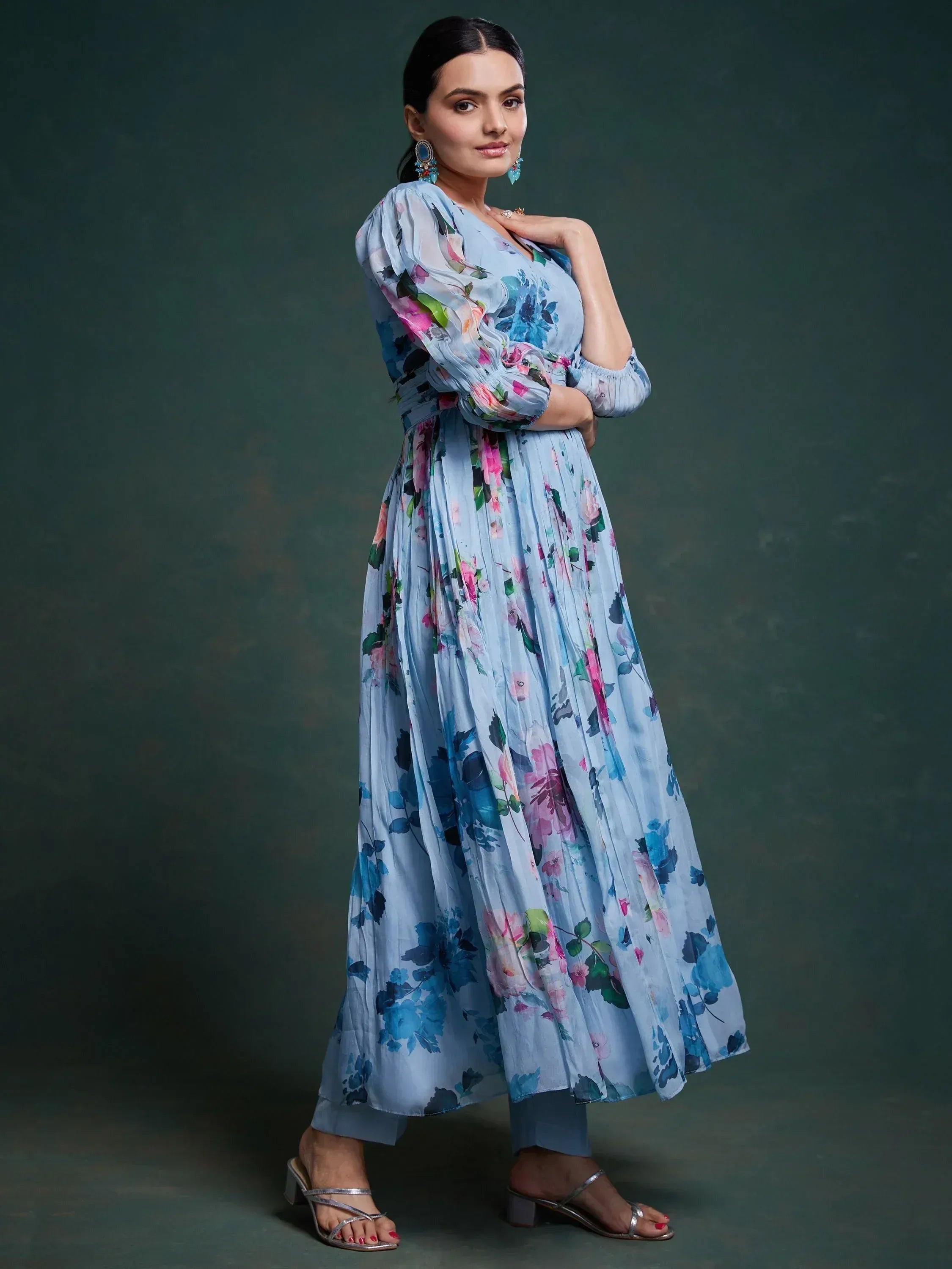 Blue floral ethnic gown with puff sleeves and pleated skirt, paired with silver heels for festive occasions