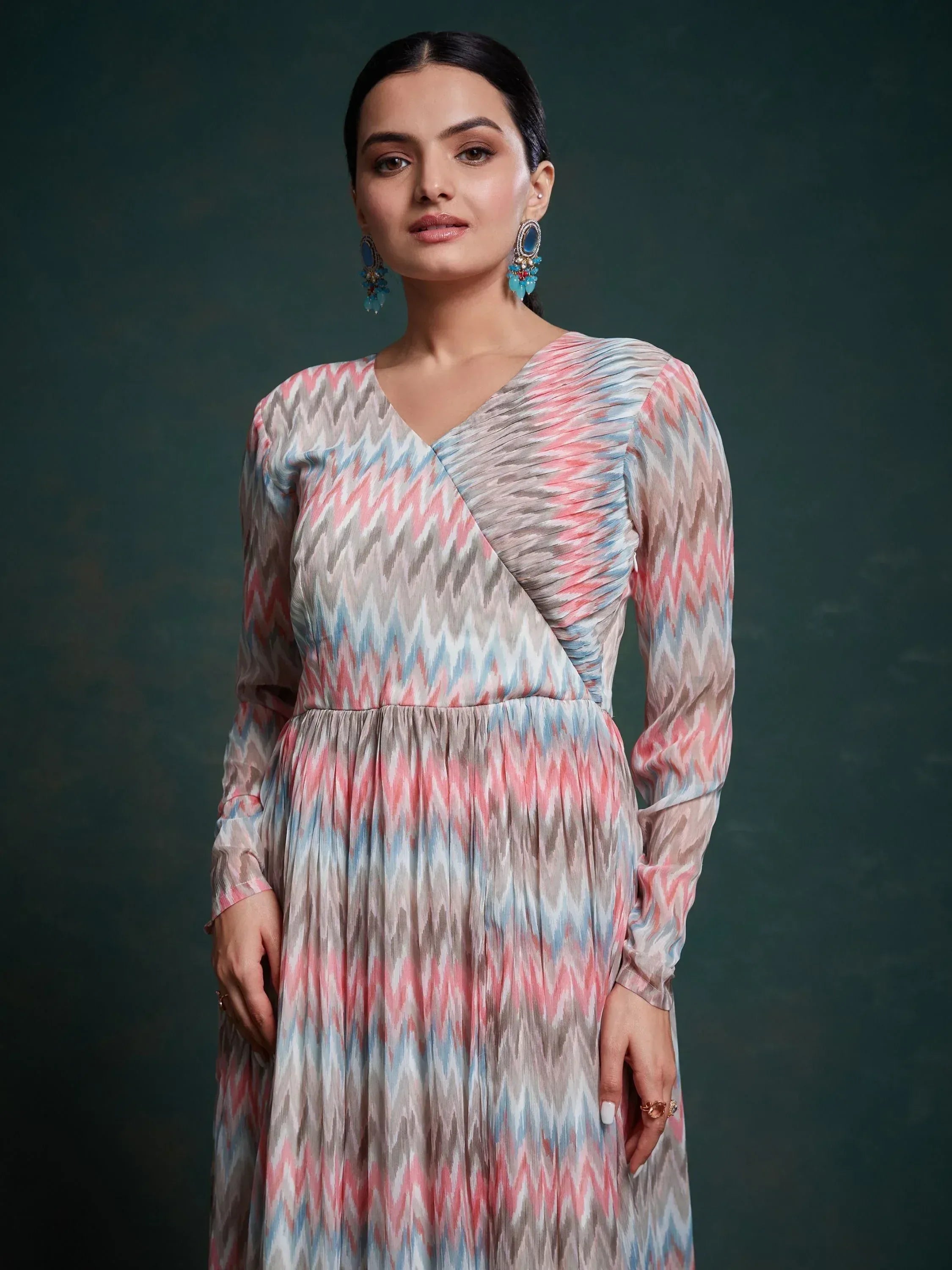 Woman wearing long sleeve multicolor ikat print ethnic gown with blue earrings