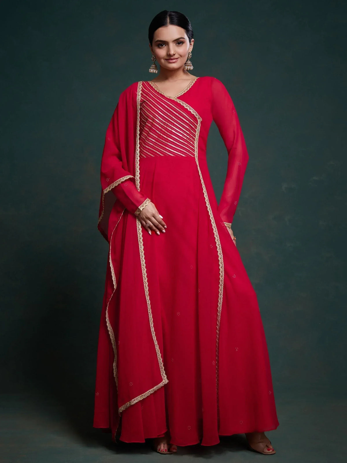 Red ethnic gown with gold embroidery and sheer sleeves, perfect for Indian occasions