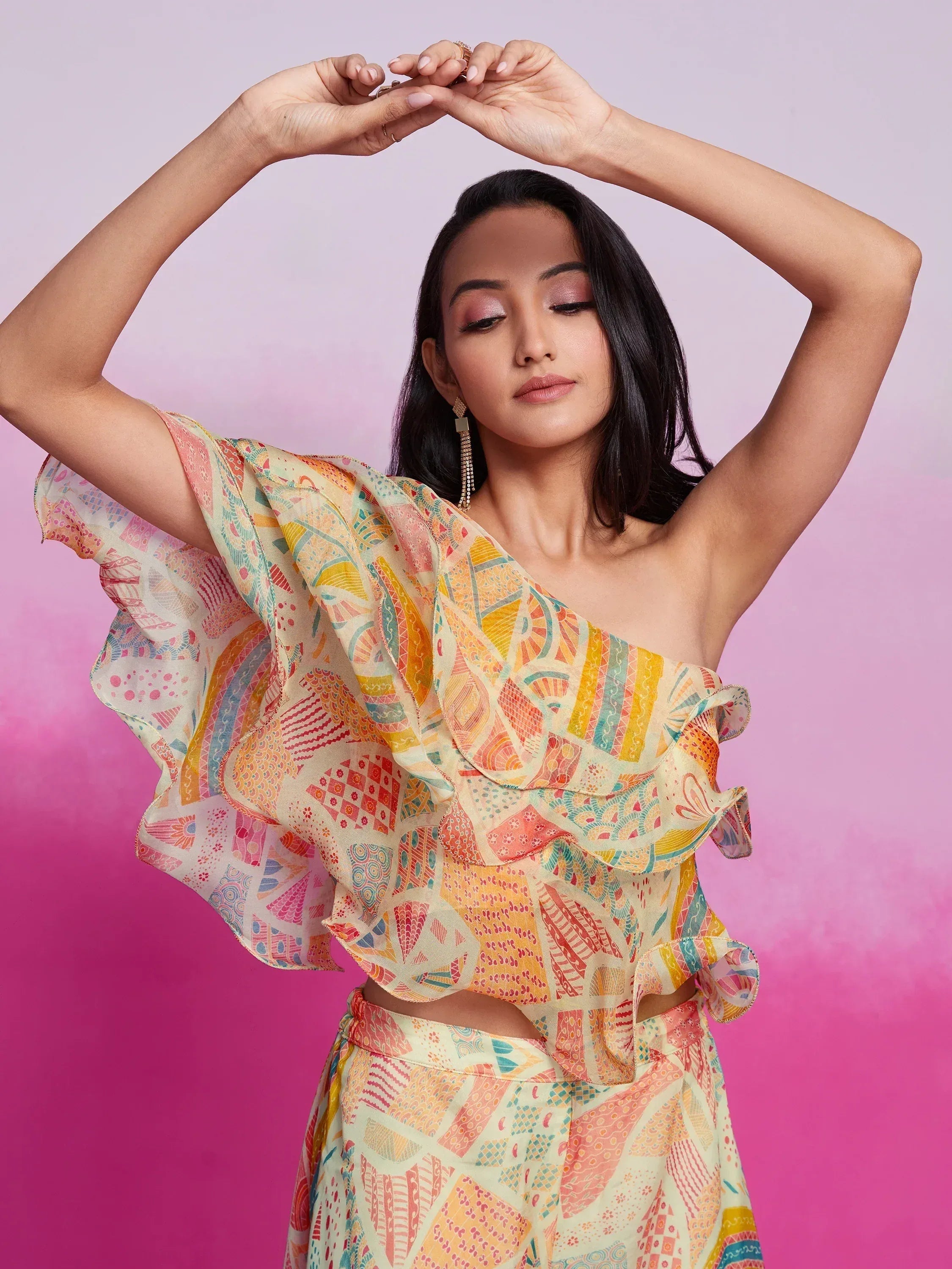 Woman in a colorful printed one-shoulder ruffle ethnic blouse with matching skirt