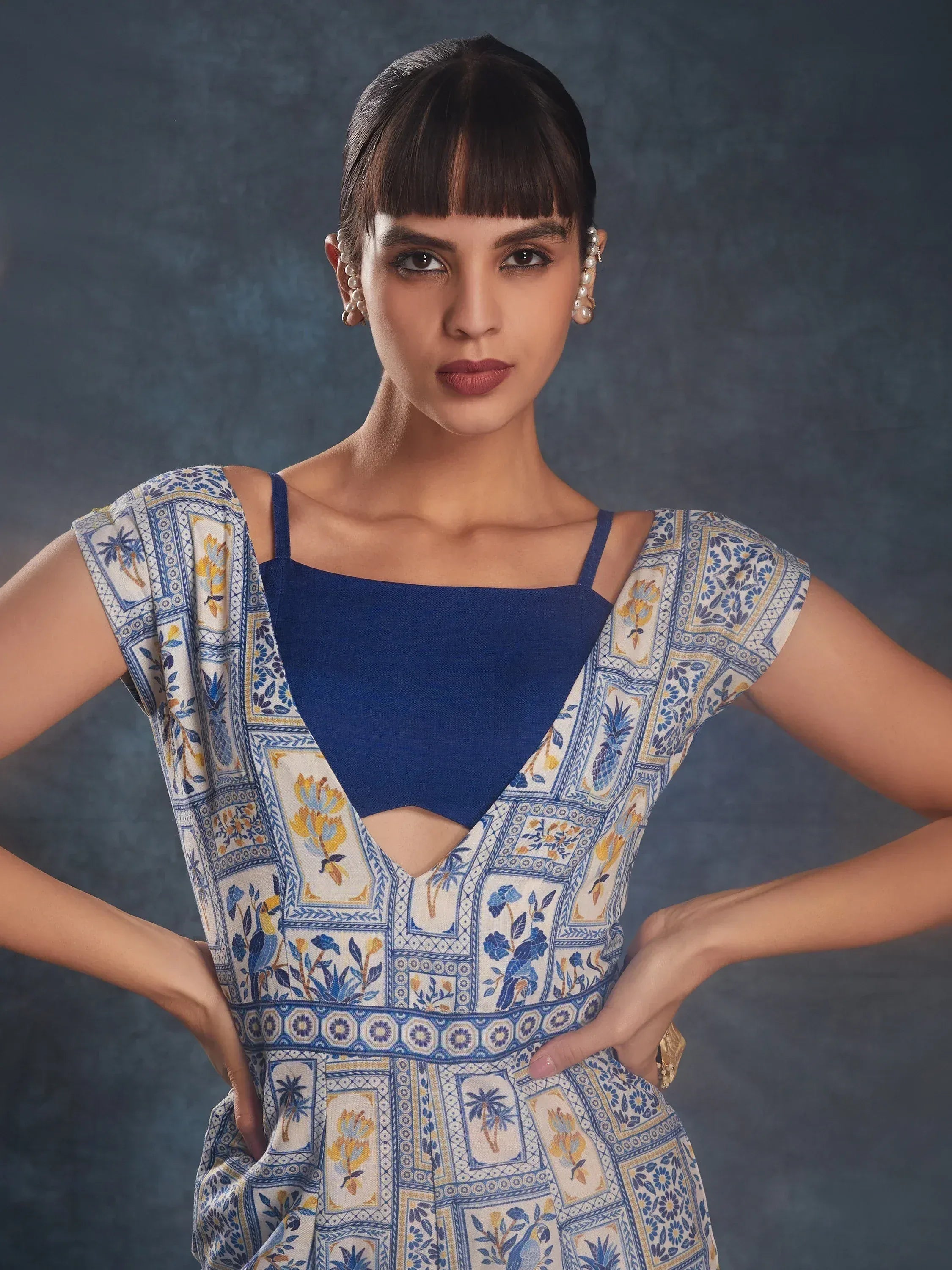 Blue printed ethnic gown with floral patterns and cut-out detail, styled with pearl earrings