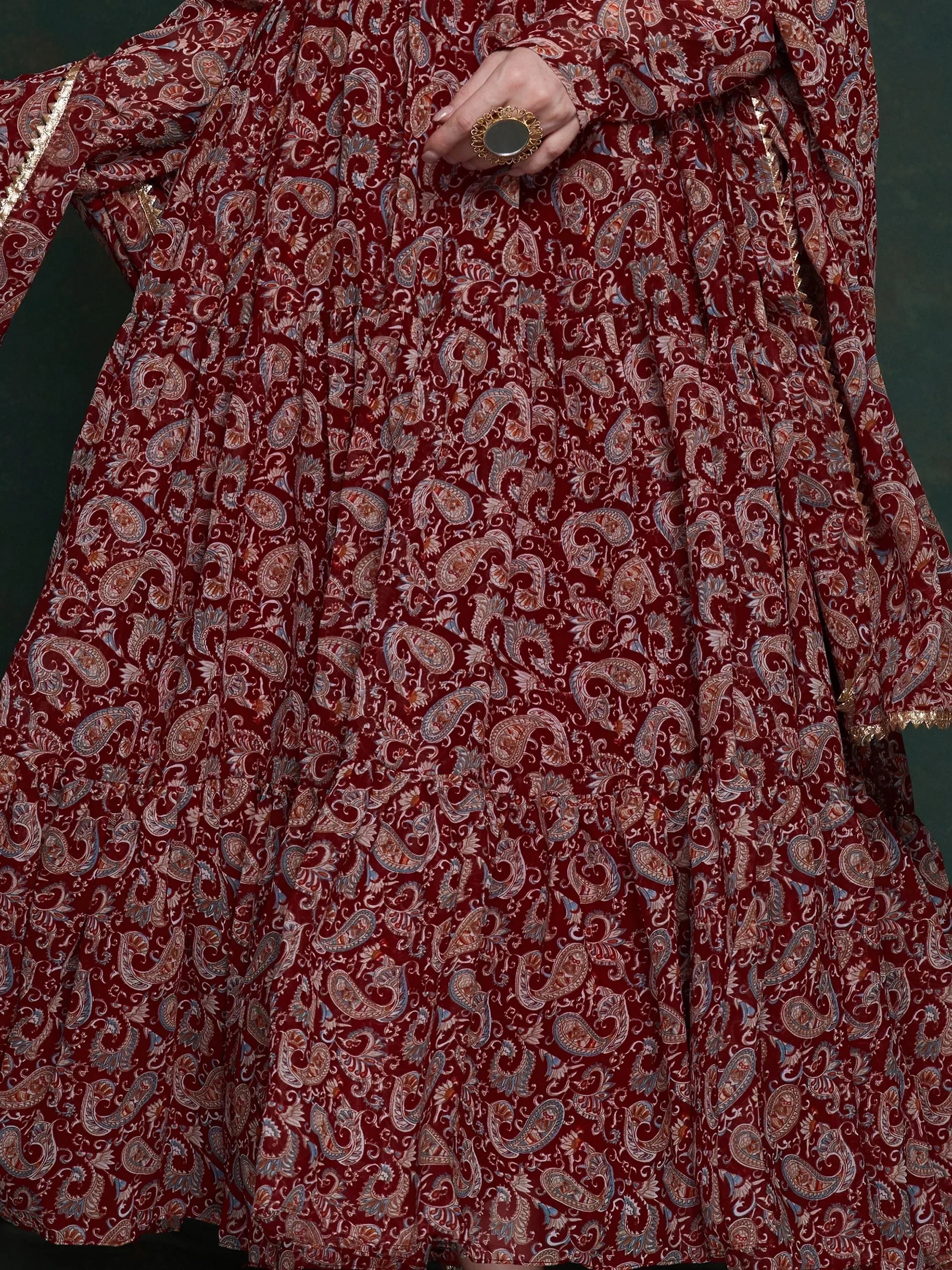 Red paisley print ethnic gown with gold embroidery and statement ring