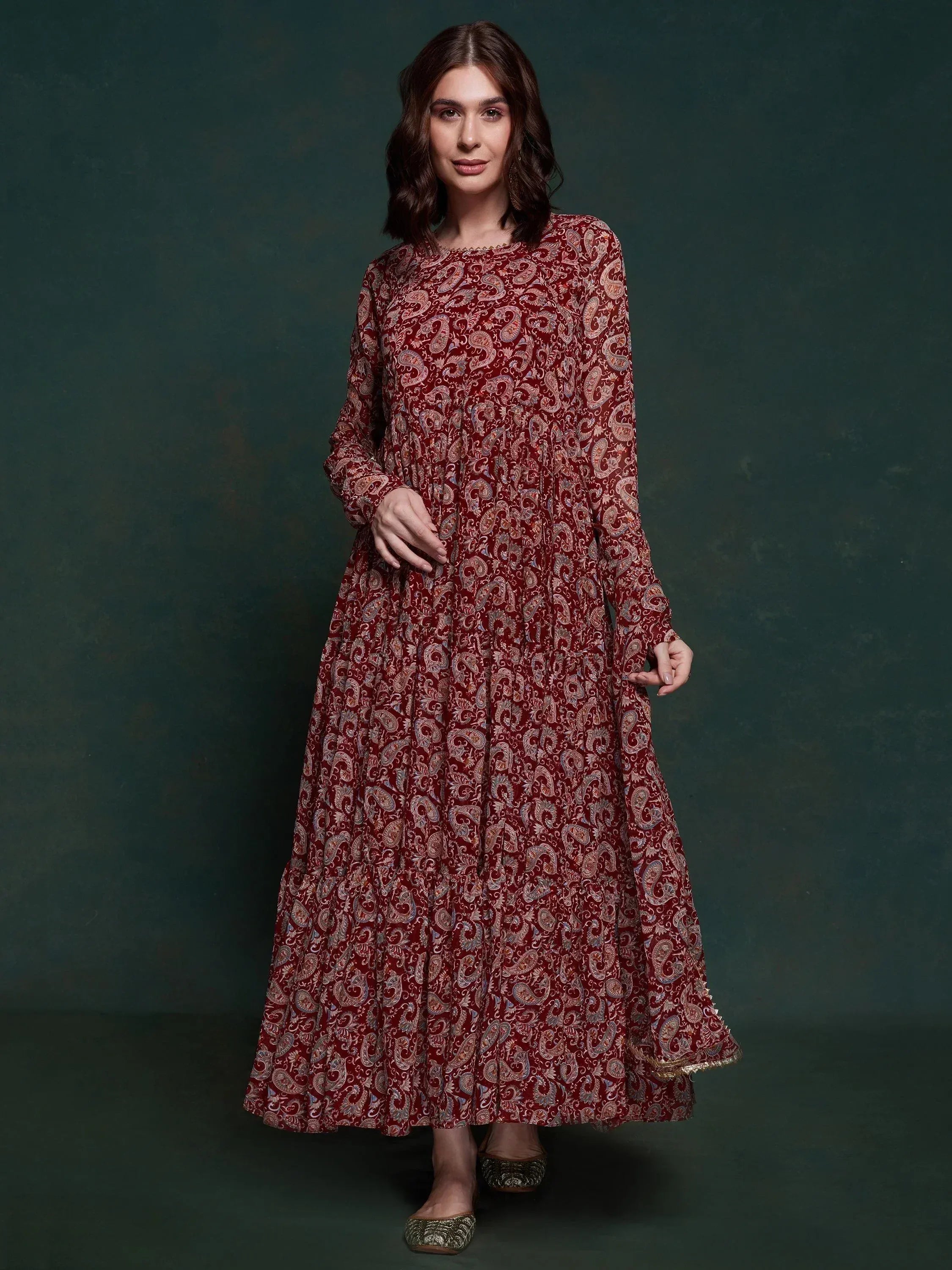 Woman wearing maroon paisley printed ethnic gown with long sleeves and round neckline