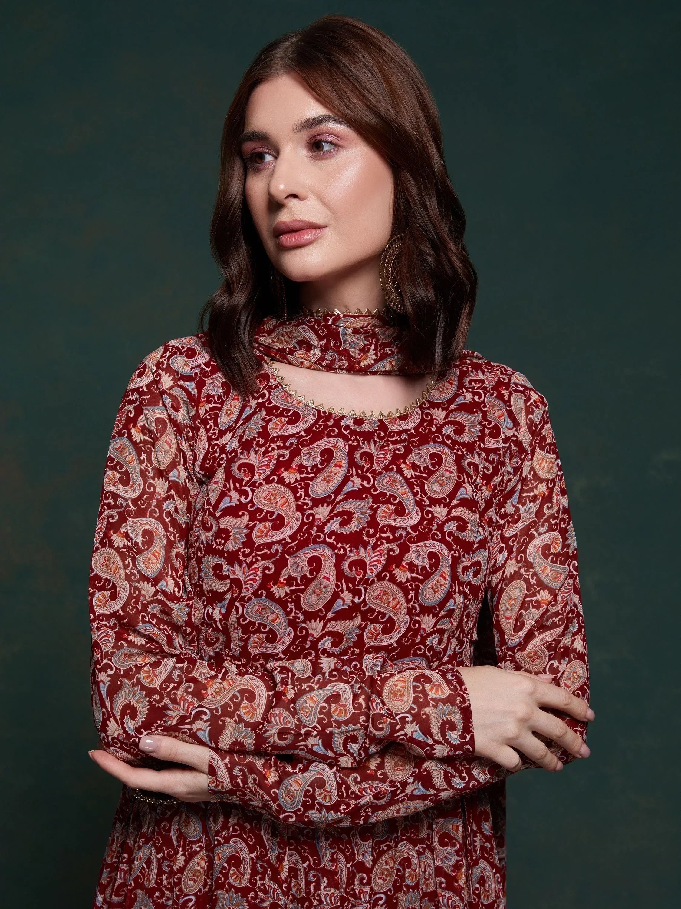 Woman wearing a maroon paisley print ethnic dress with high neck and long sleeves
