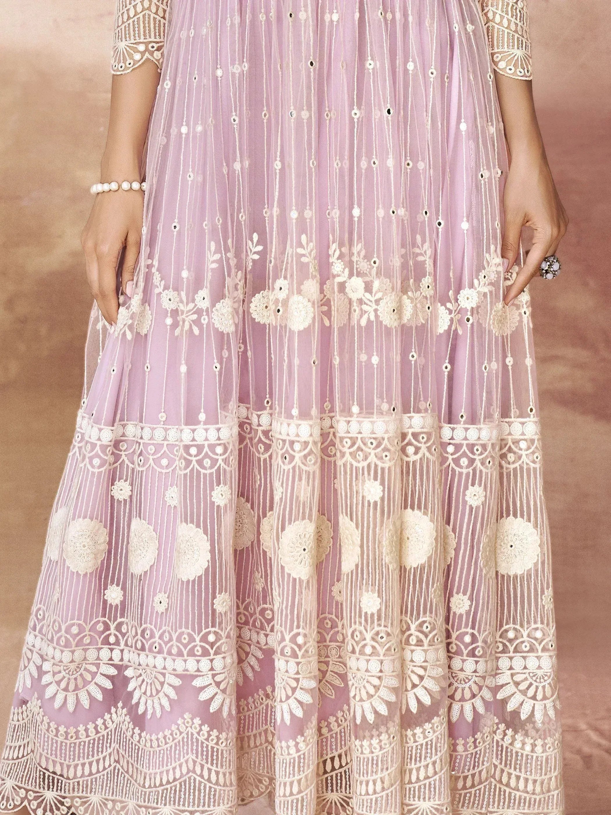Lavender ethnic gown with white floral embroidery and mirror work, perfect for Indian occasions.