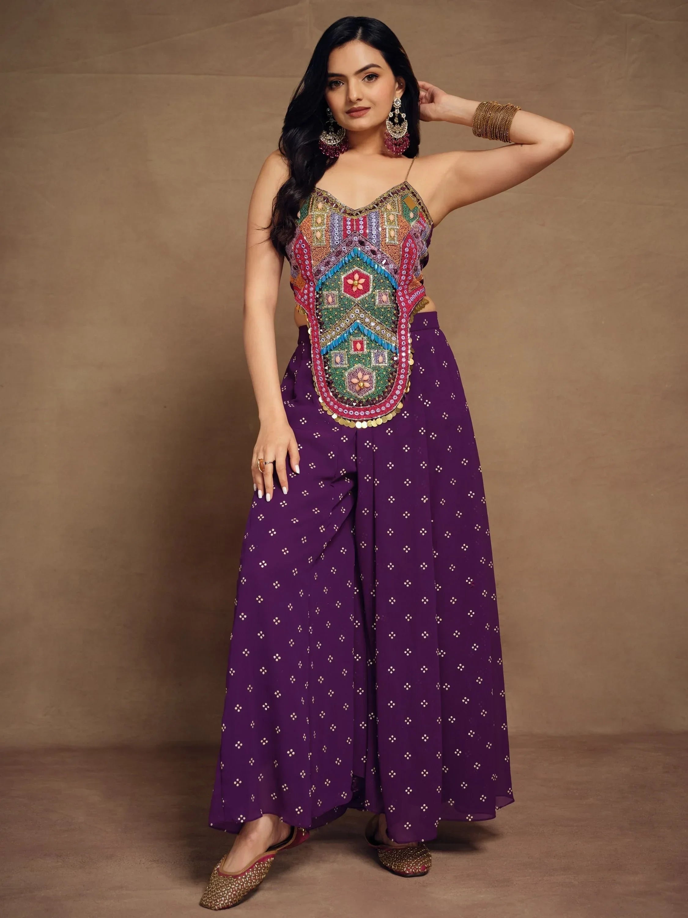Woman in a purple ethnic palazzo set with colorful embroidered crop top and traditional jewelry