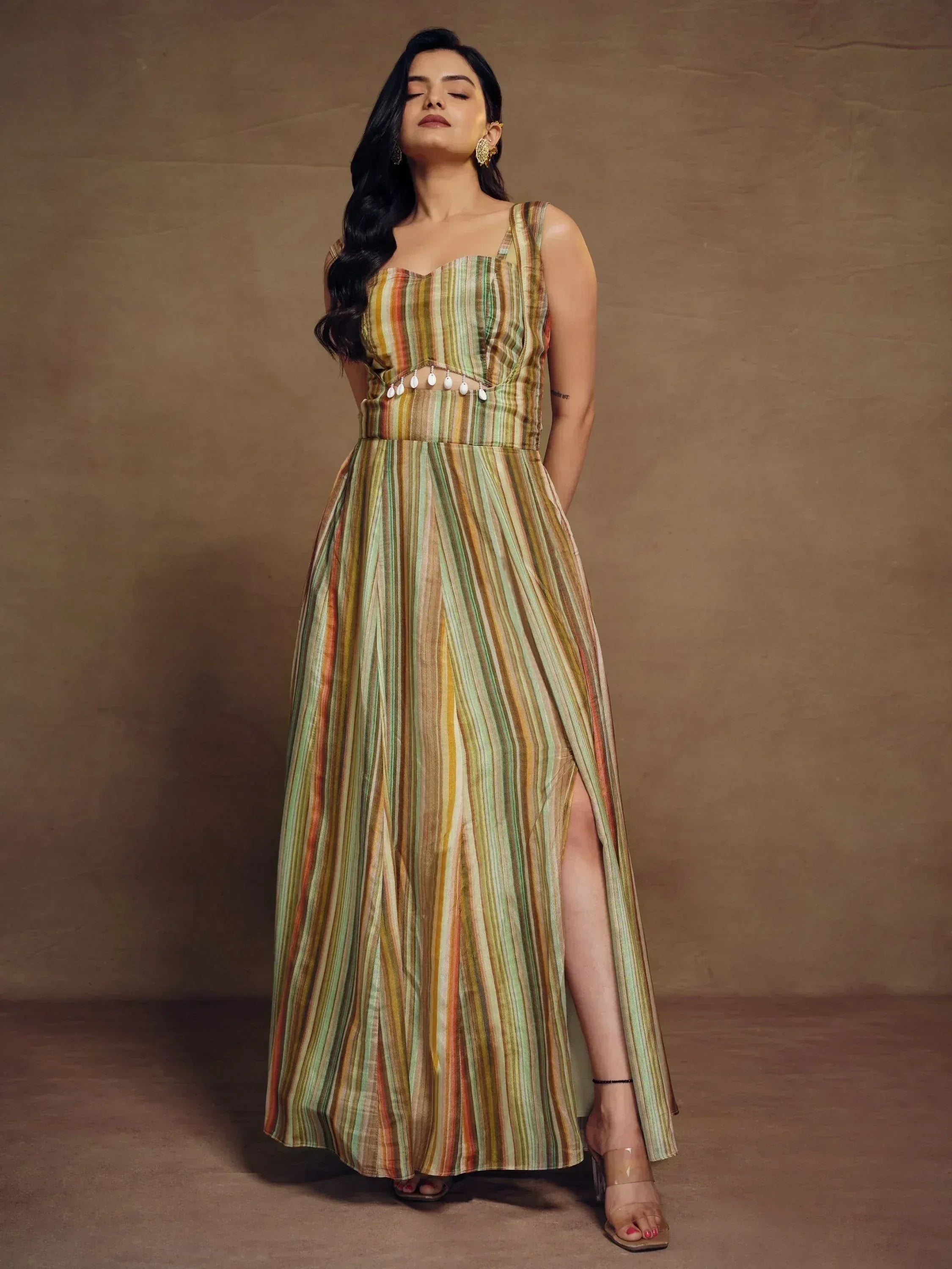 Woman in striped ethnic gown with cut-out waist, perfect for Indian festive occasions.
