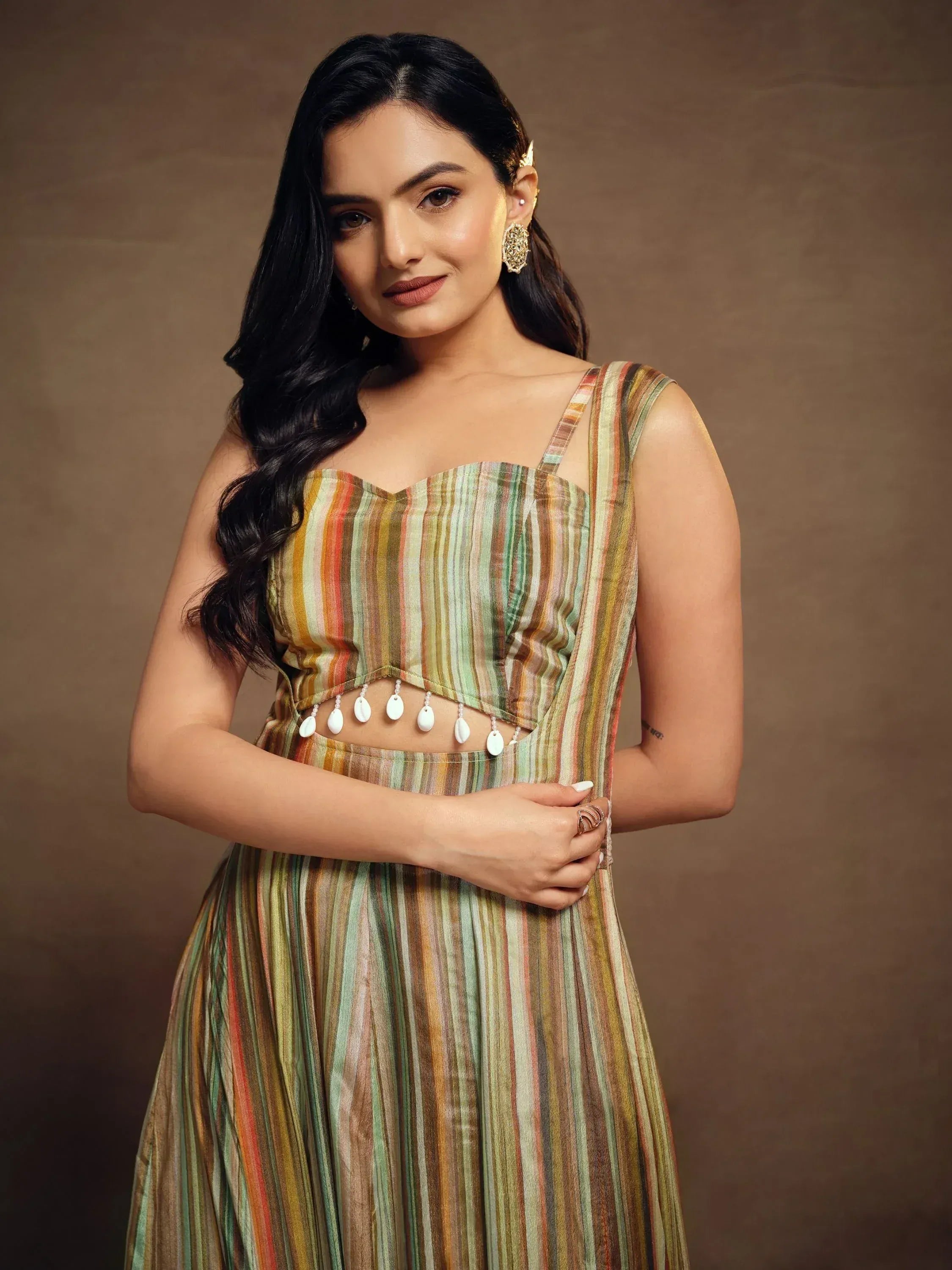 Woman in striped ethnic gown with shell embellishments, perfect for Indian occasions