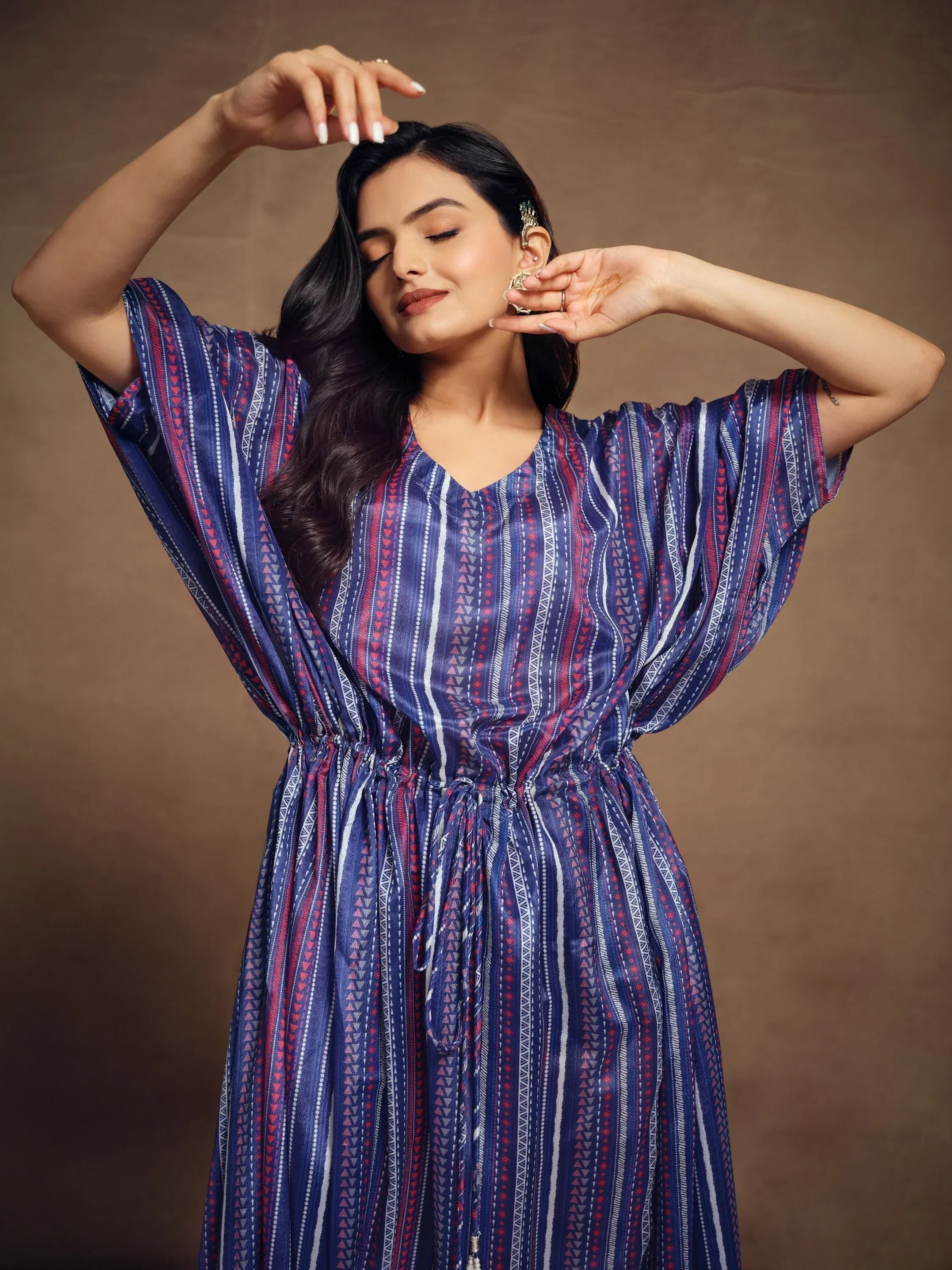 Woman wearing a stylish blue and purple kaftan dress with geometric patterns