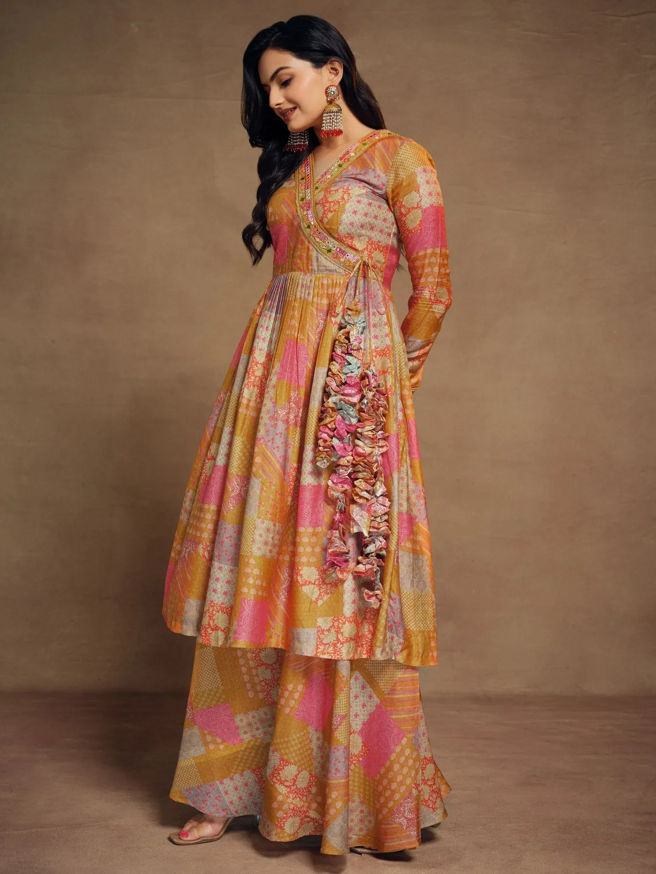 Woman in colorful patchwork ethnic anarkali gown with ruffled side panel, perfect for festive occasions.