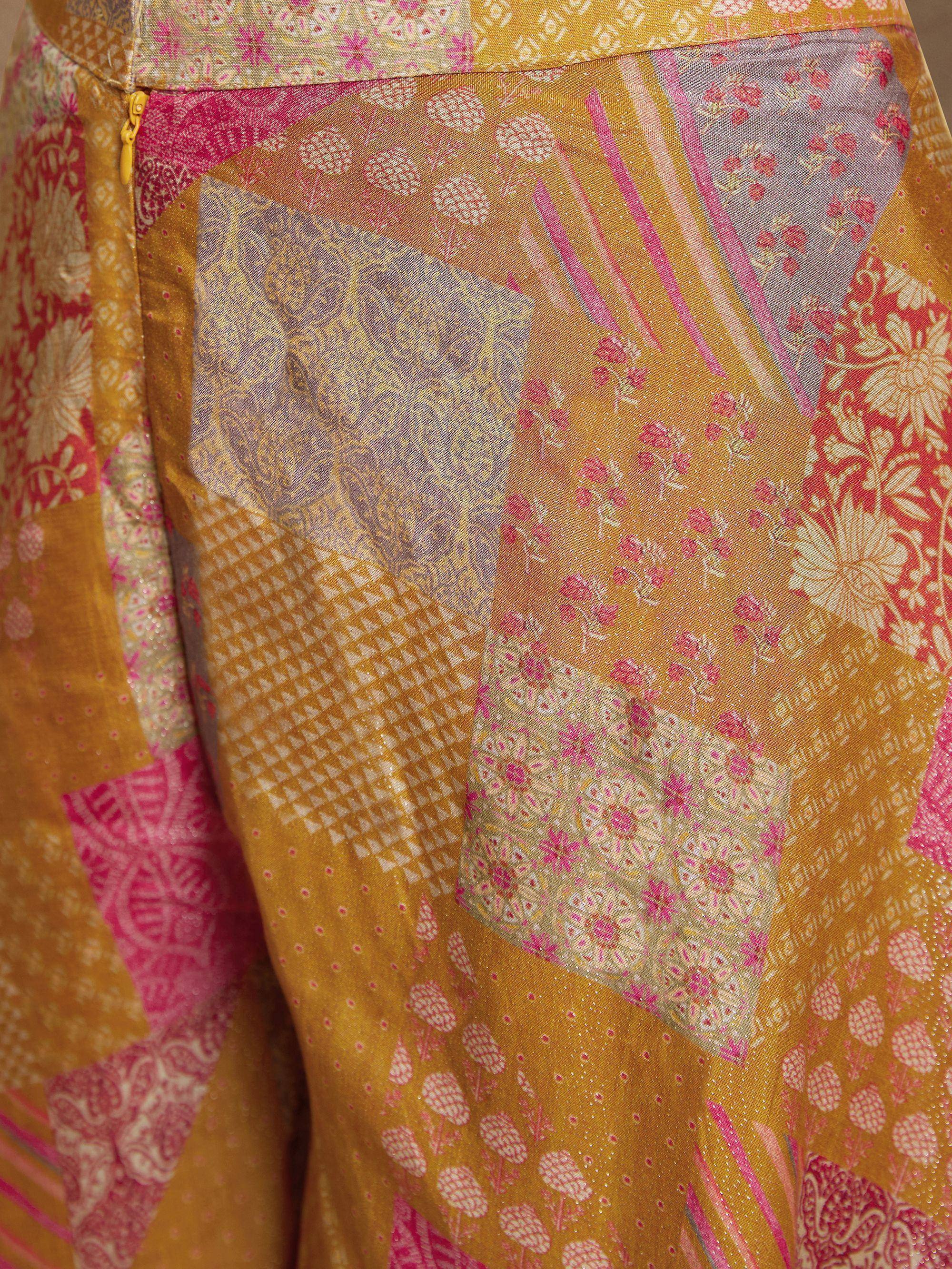 Vibrant patchwork ethnic gown with floral and geometric prints in mustard, pink, and gold tones