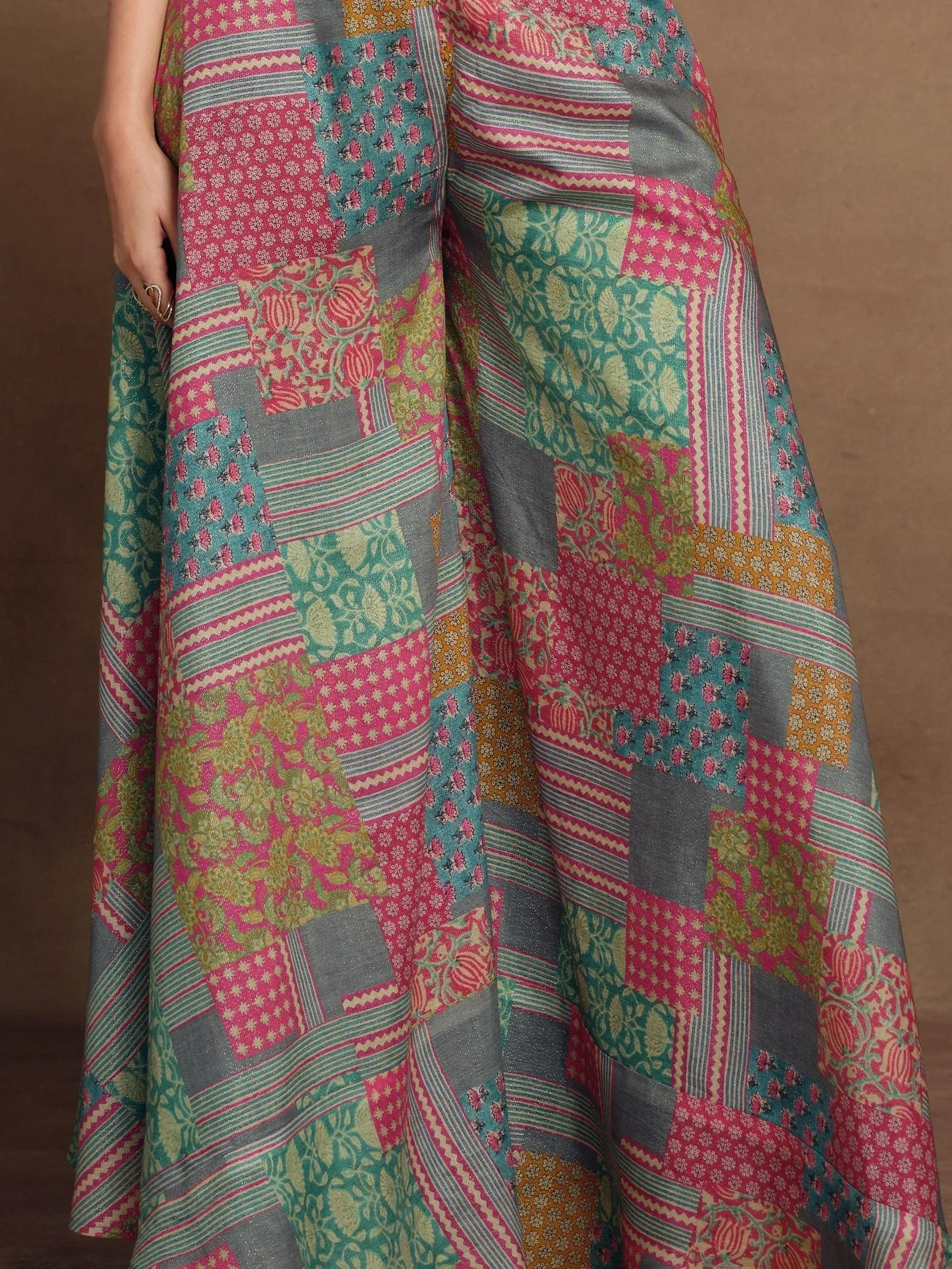 Colorful patchwork ethnic gown with floral and geometric prints in pink, teal, and gold tones