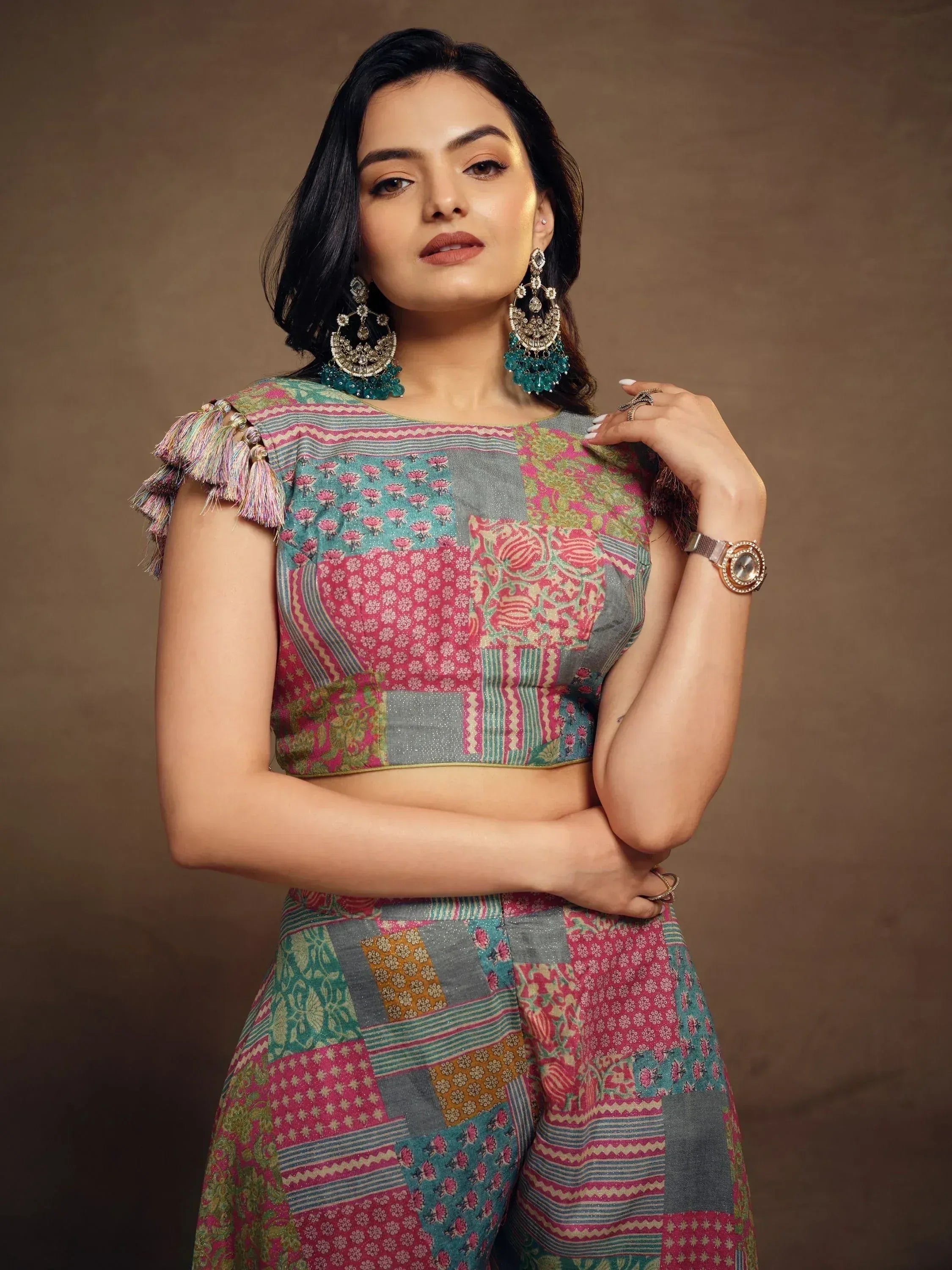 Woman in colorful patchwork Indian ethnic wear with tassel sleeves and statement earrings