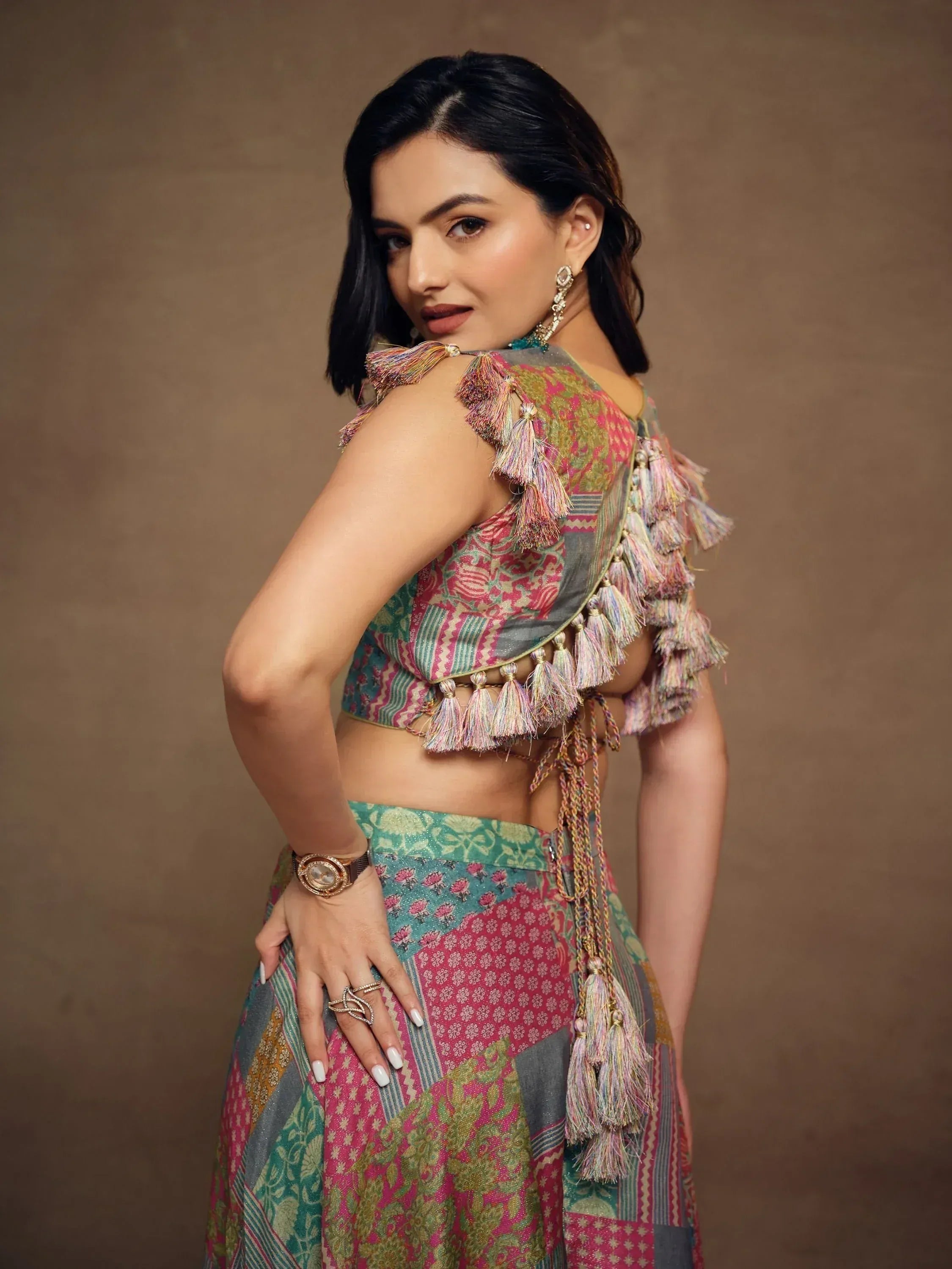 Woman in colorful Indian ethnic lehenga choli with tassel detailing, perfect for festive occasions.
