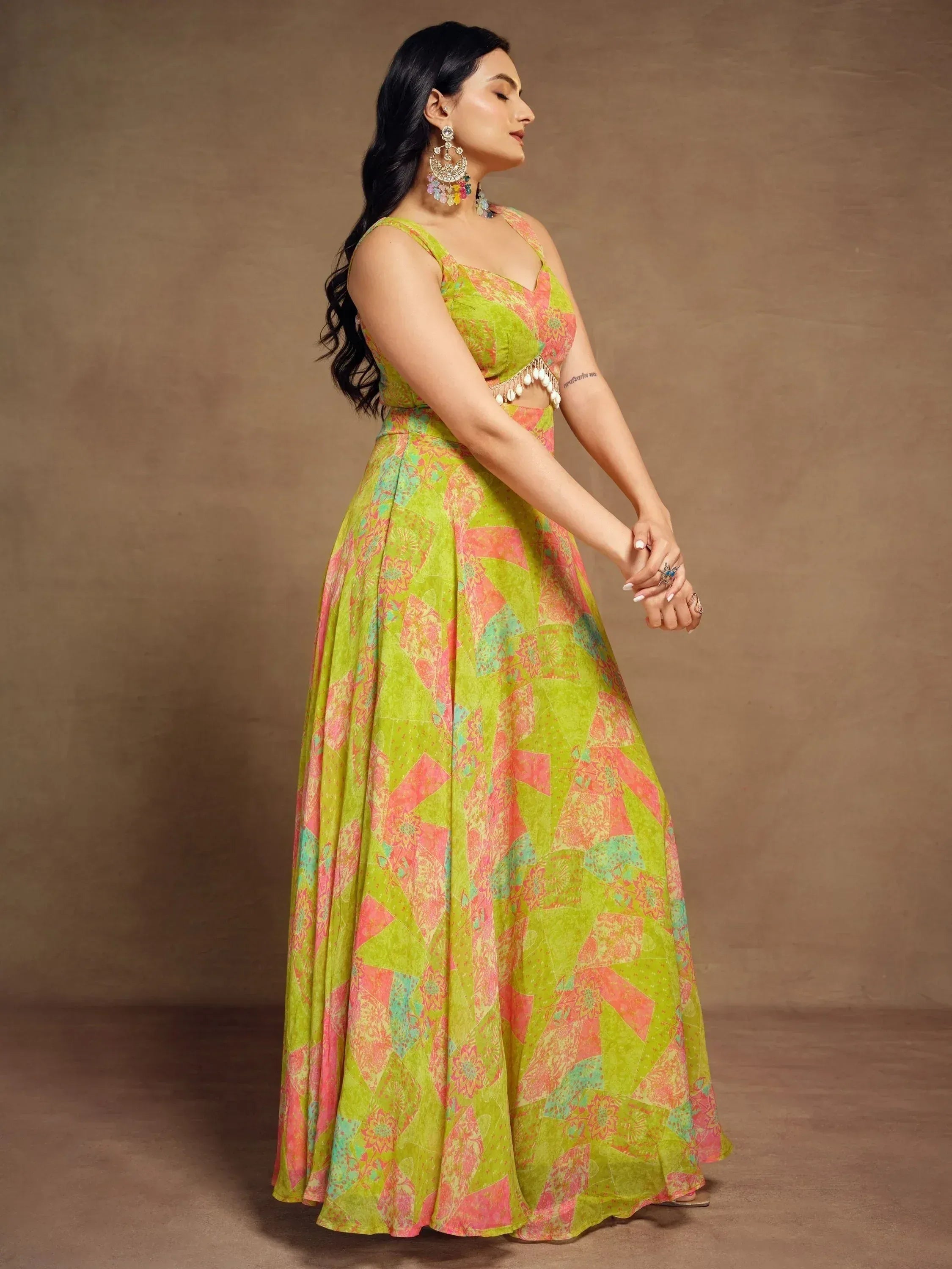 Woman in vibrant green and pink printed lehenga choli with floral patterns, ethnic Indian wear