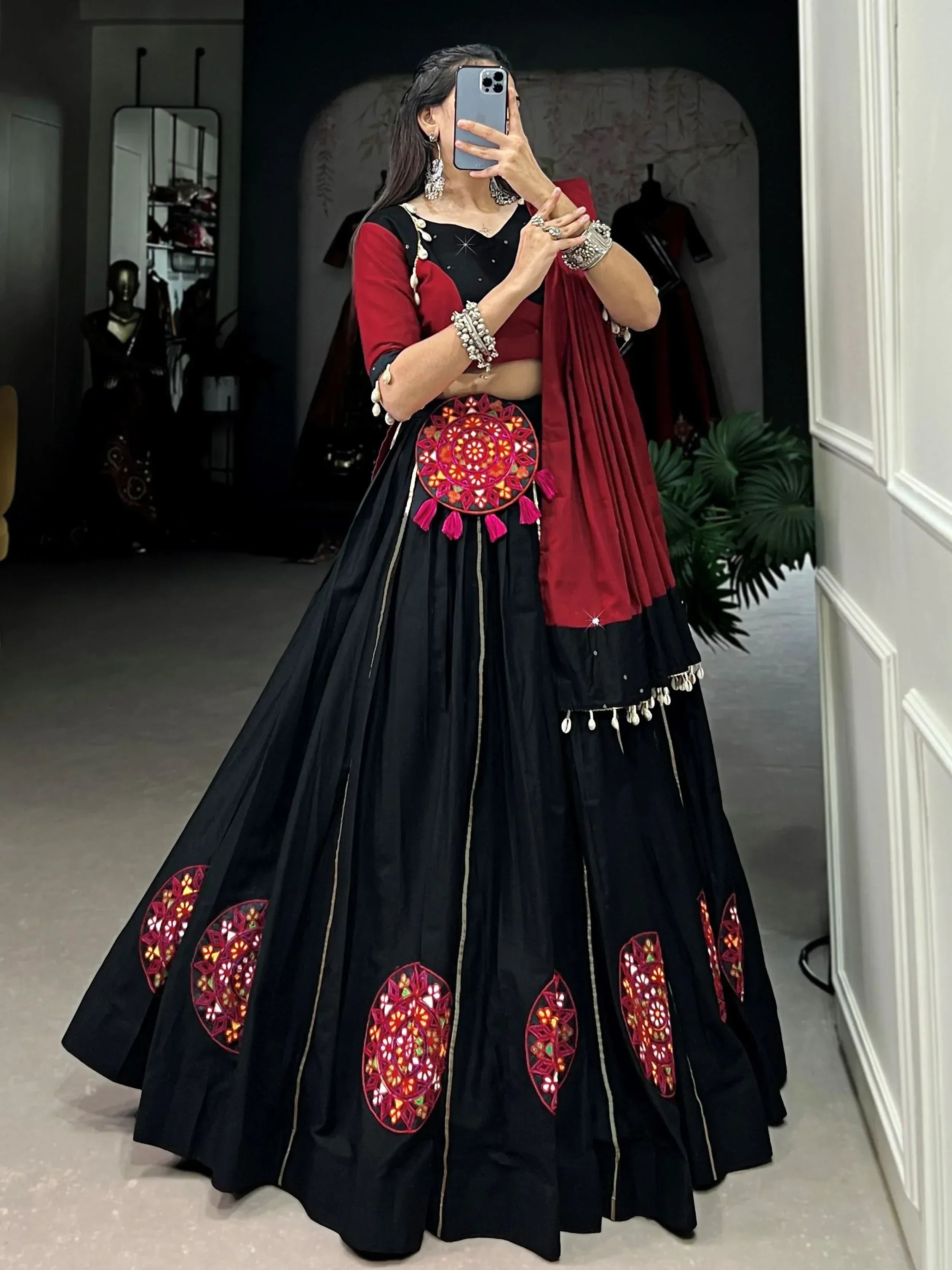 Black and maroon ethnic lehenga choli with mirror work and tassels, perfect for Indian weddings or festivals