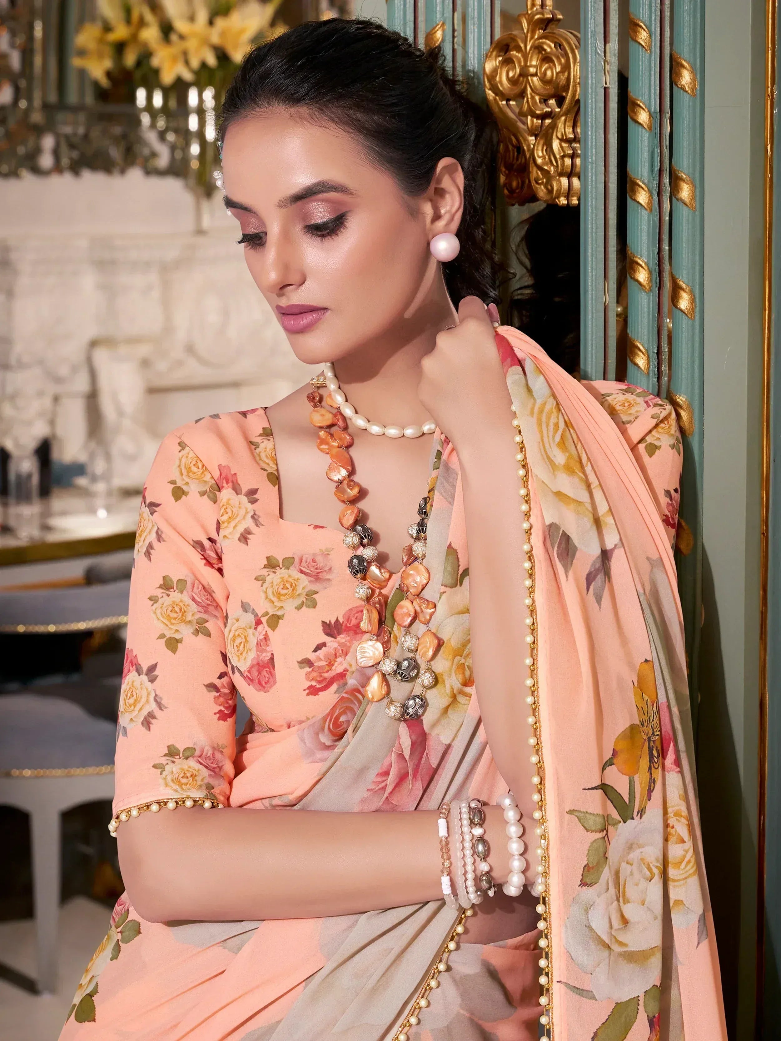 Elegant peach floral saree with pearl jewelry, perfect for Indian ethnic occasions