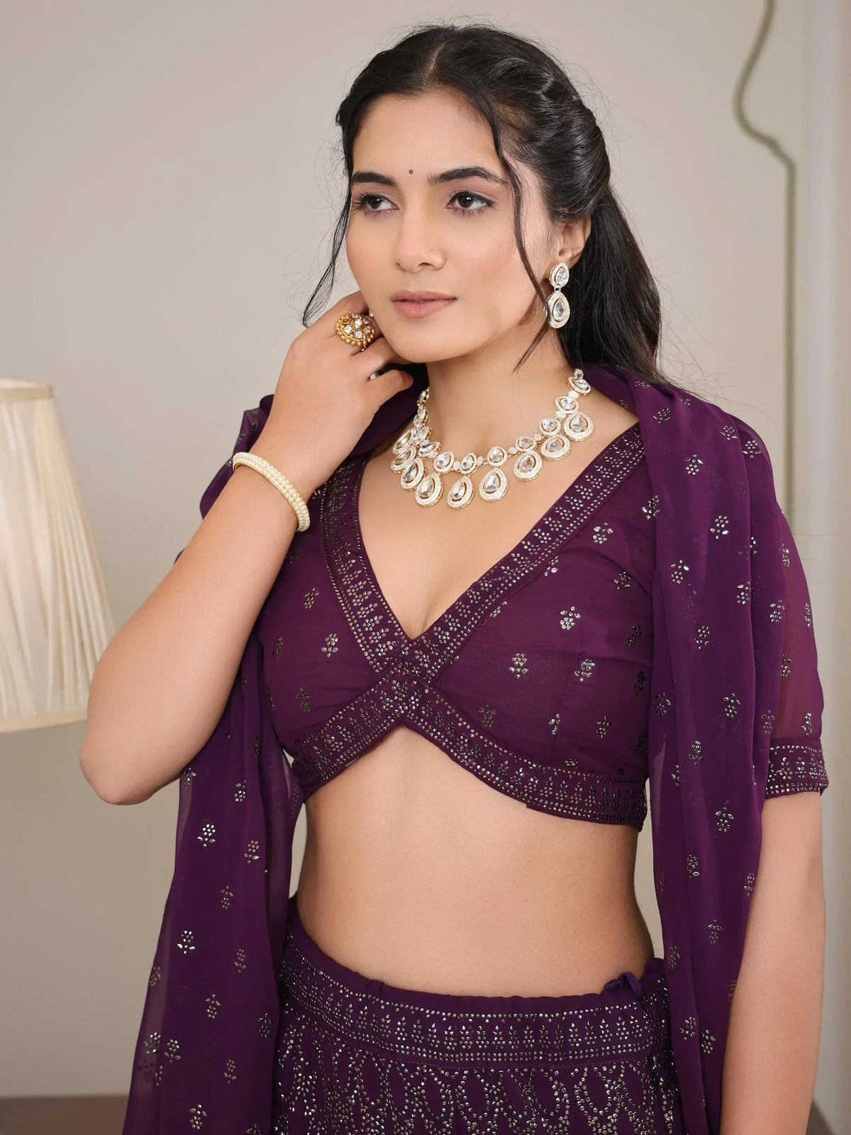 Purple embroidered lehenga choli with matching dupatta and kundan jewelry for Indian ethnic wear