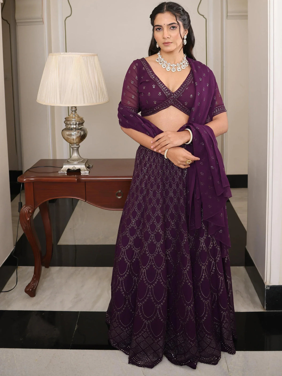 Purple designer lehenga choli with intricate embroidery and embellishments, perfect for Indian ethnic wear occasions.
