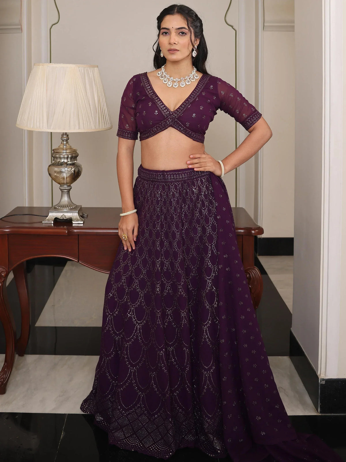 Purple designer lehenga choli with intricate embroidery and embellishments, perfect for Indian ethnic wear occasions.