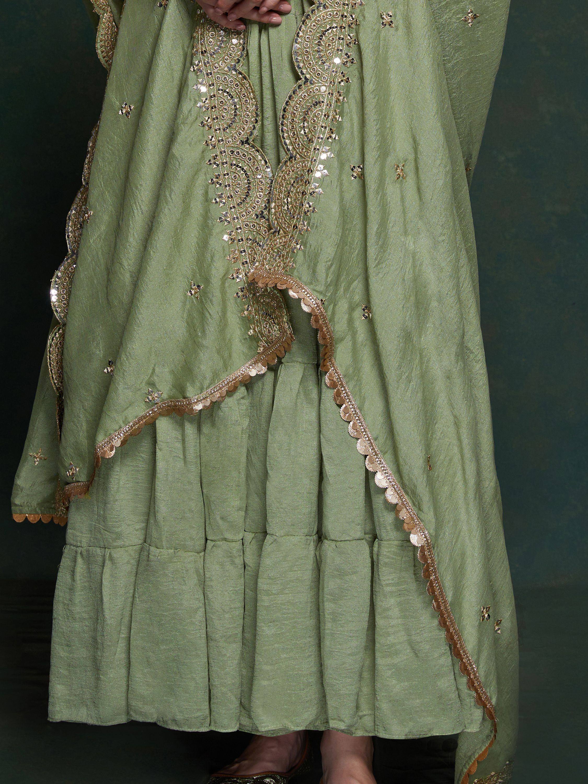Green ethnic gown with gold mirror work and scalloped hem, perfect for Indian occasions.