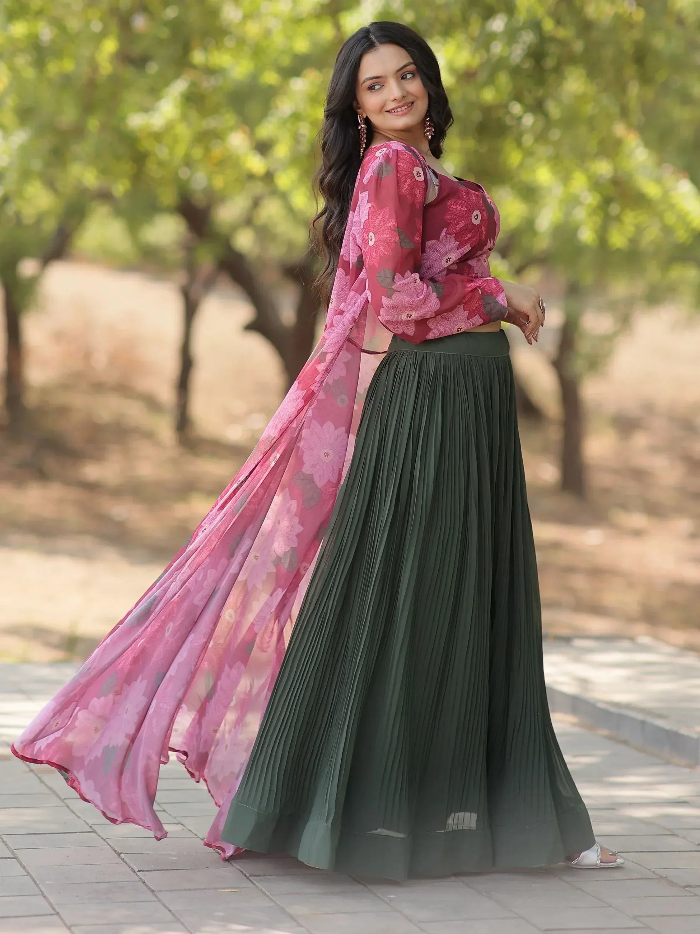 Woman in floral pink top with green pleated skirt, Indian ethnic wear for festive occasions