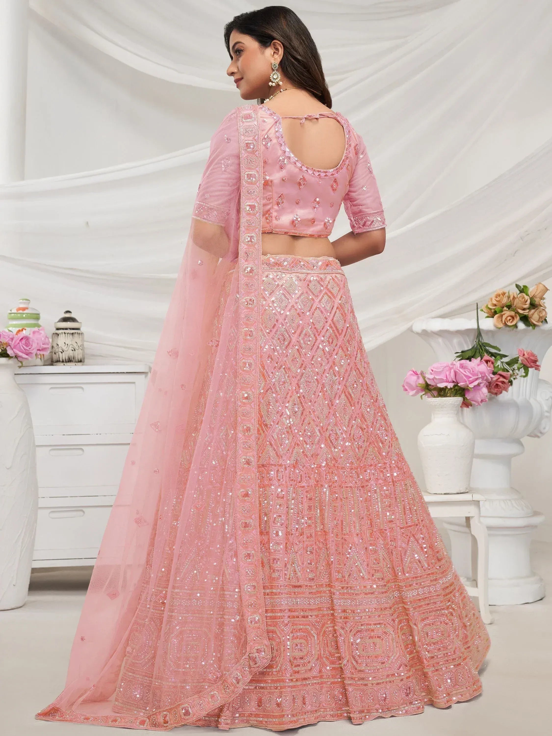 Pink designer lehenga choli with intricate embroidery and sequin work, perfect for weddings and festive occasions.