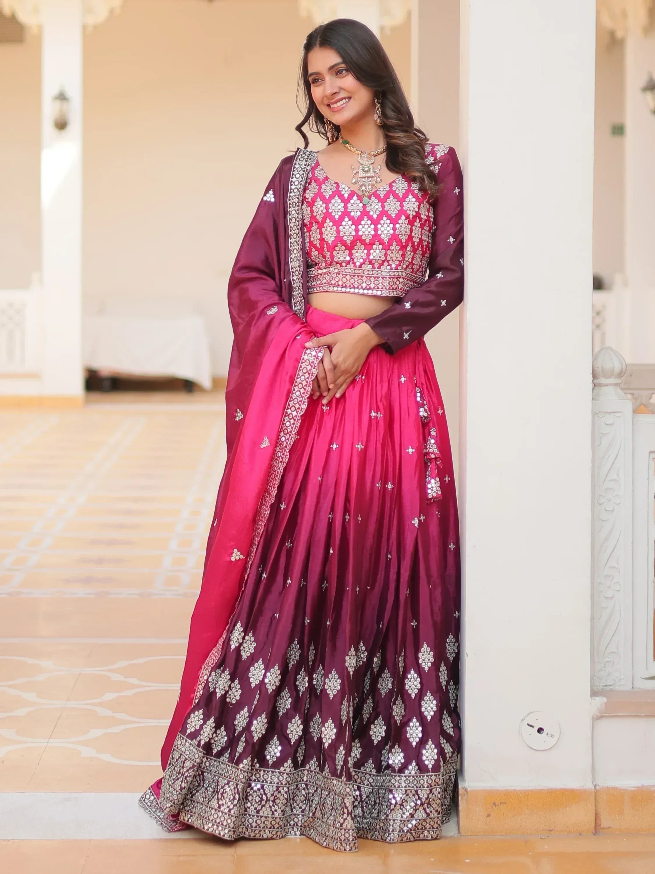 Woman in pink and maroon designer lehenga choli with mirror work, perfect for Indian ethnic occasions