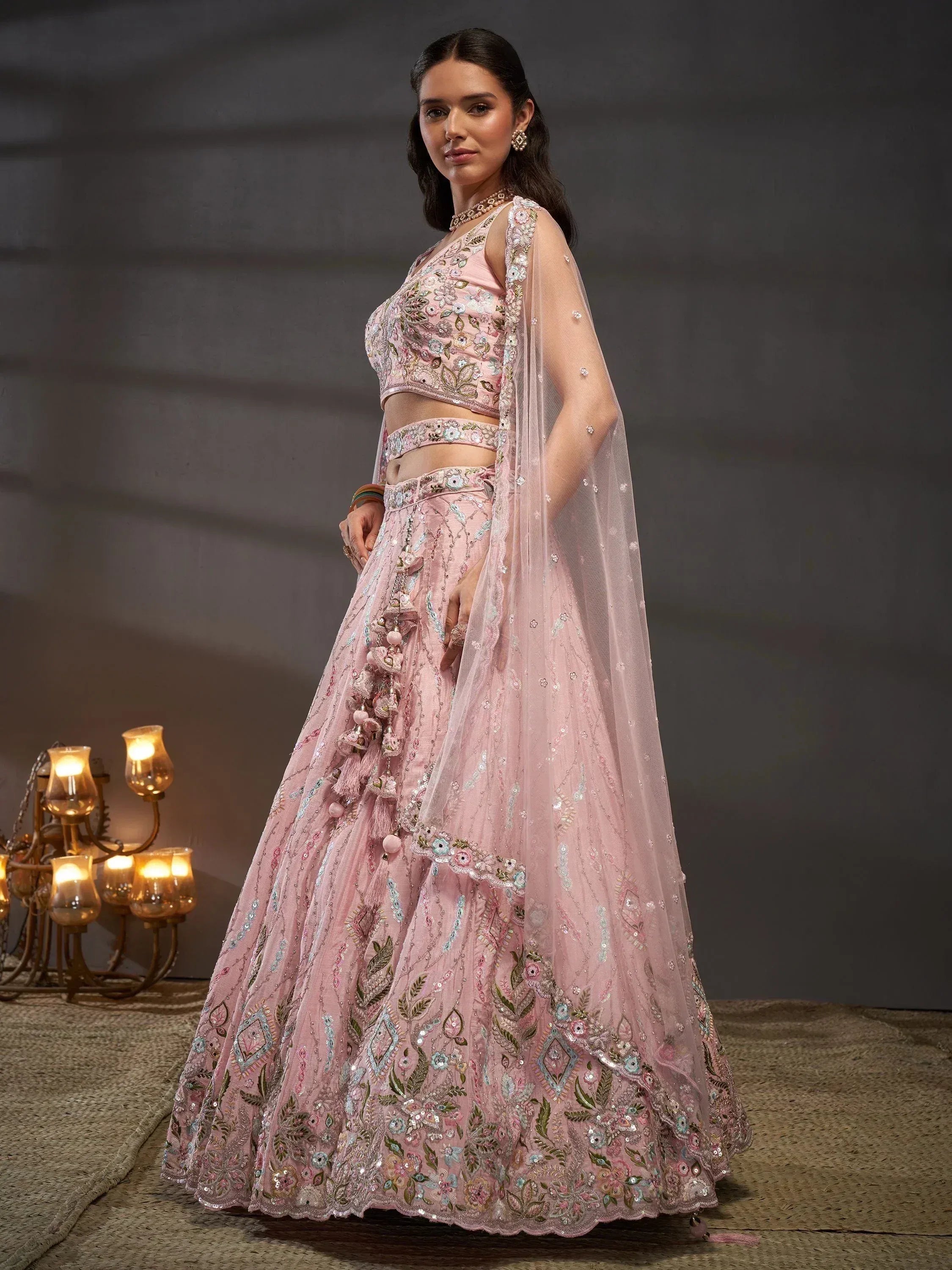 Pink embroidered lehenga choli with floral motifs and sheer dupatta, perfect for Indian weddings and festive occasions.