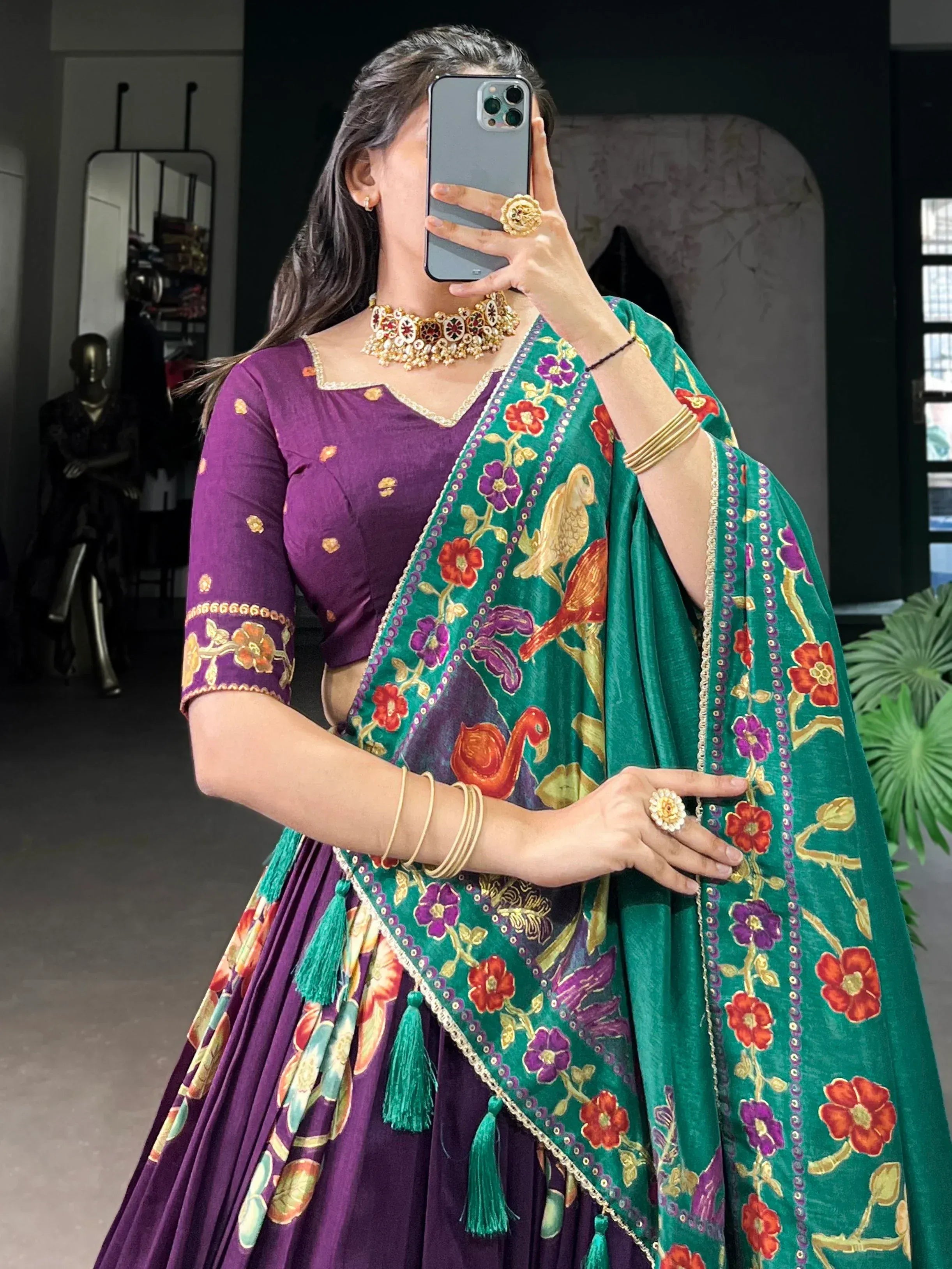 Purple lehenga choli with green floral dupatta, bird embroidery, and gold jewelry for Indian ethnic wear
