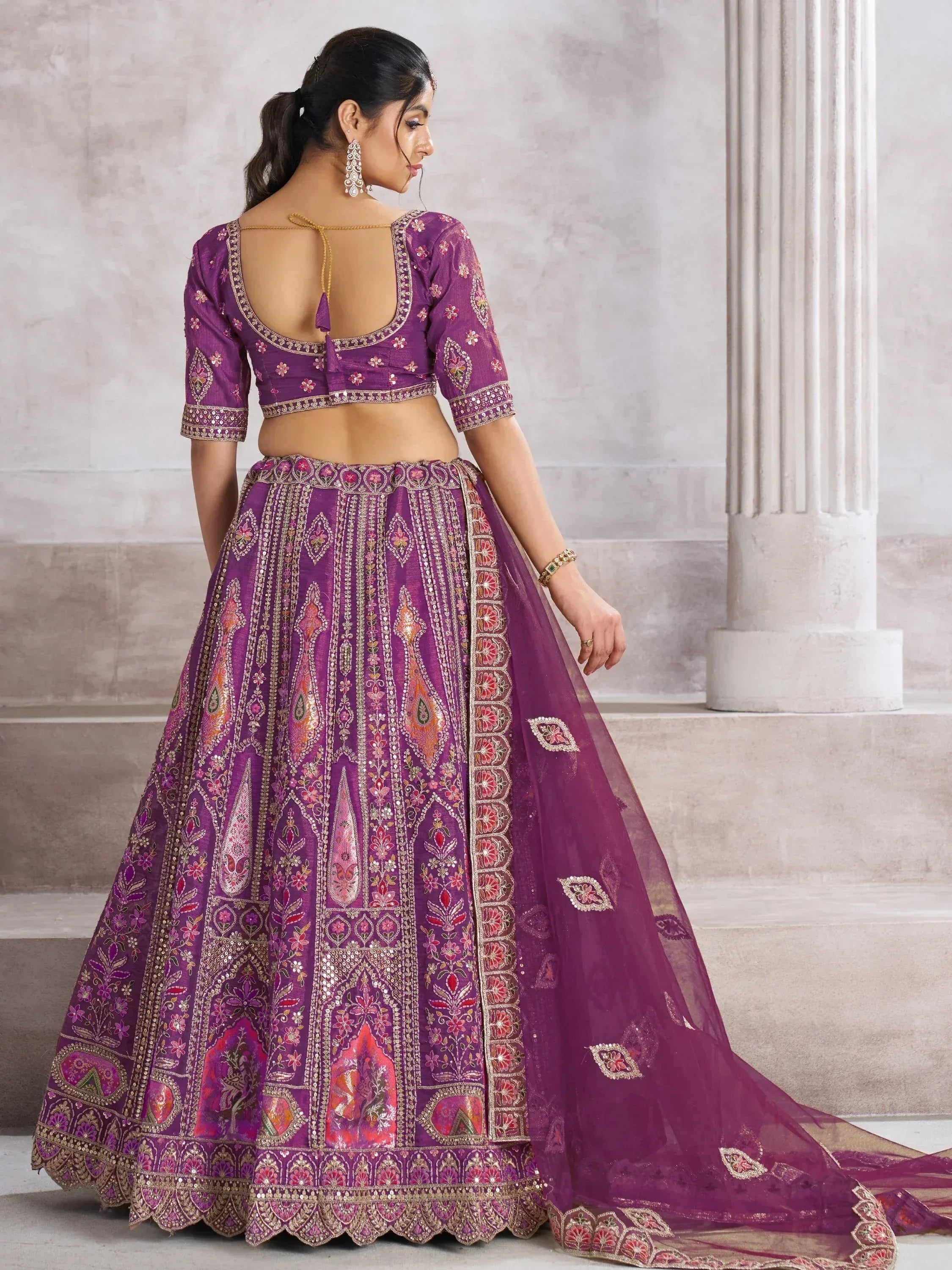 Purple embroidered lehenga choli with floral motifs and open back blouse, perfect for Indian weddings