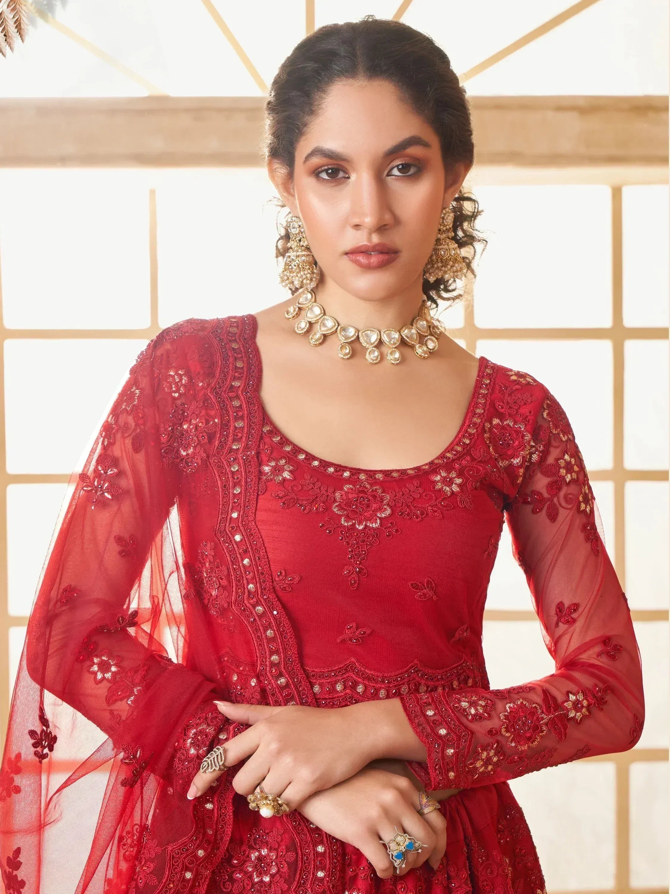 Red embroidered ethnic gown with sheer sleeves, perfect for Indian weddings or festive occasions.