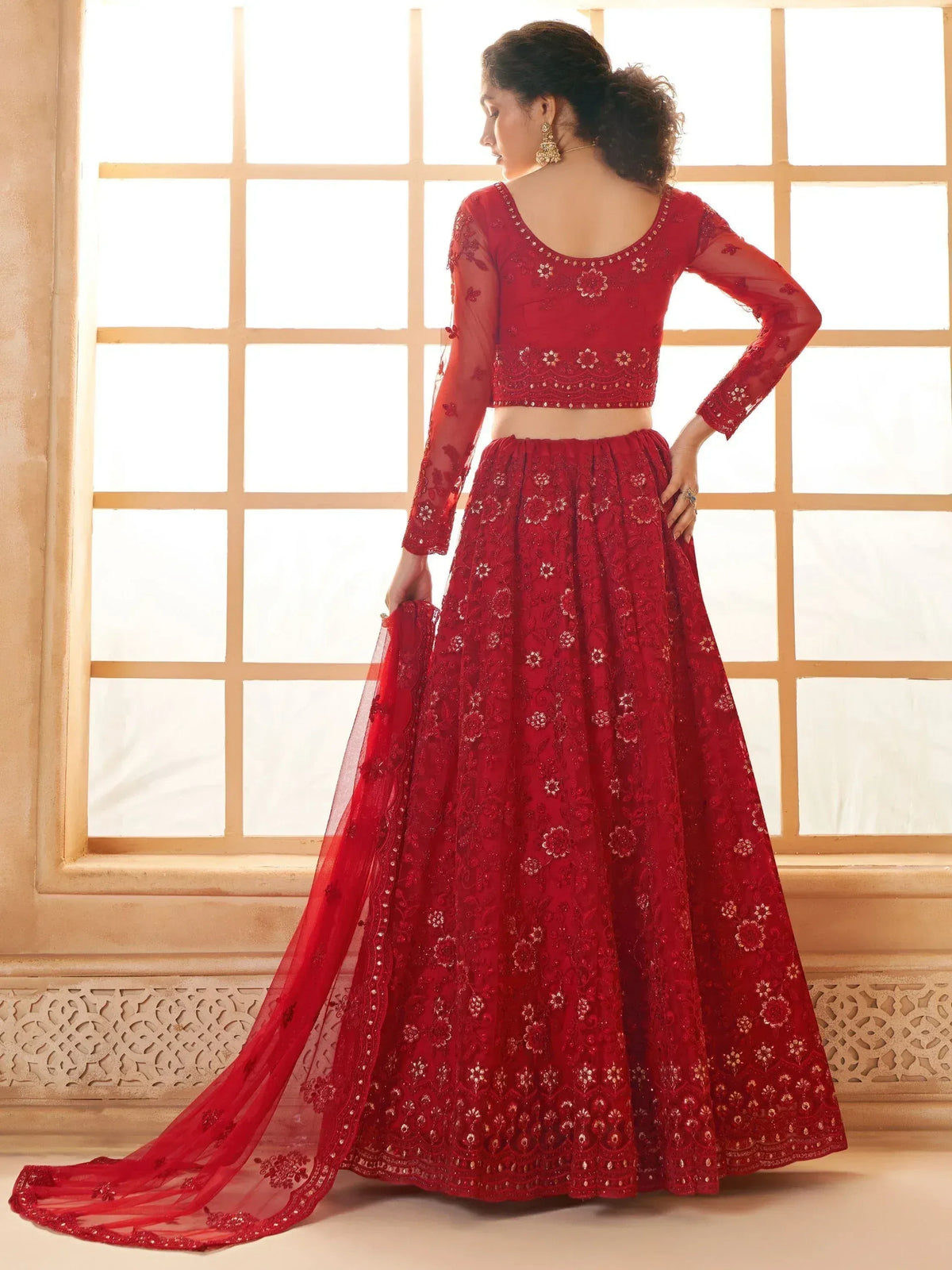 Red embroidered lehenga choli with sheer sleeves and floral motifs, perfect for Indian weddings or festive occasions.