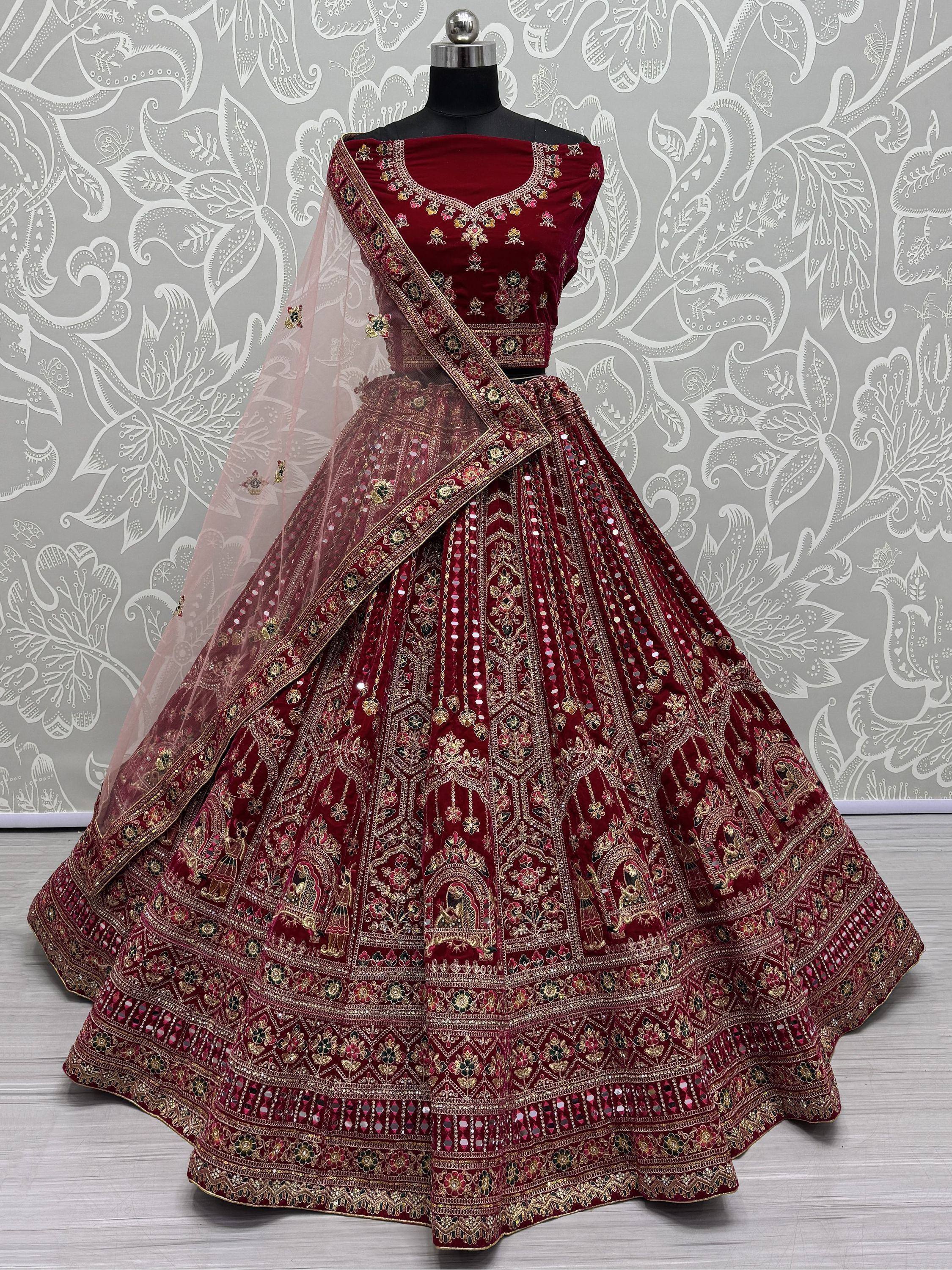 Maroon velvet designer lehenga choli with heavy gold embroidery and mirror work, perfect for weddings
