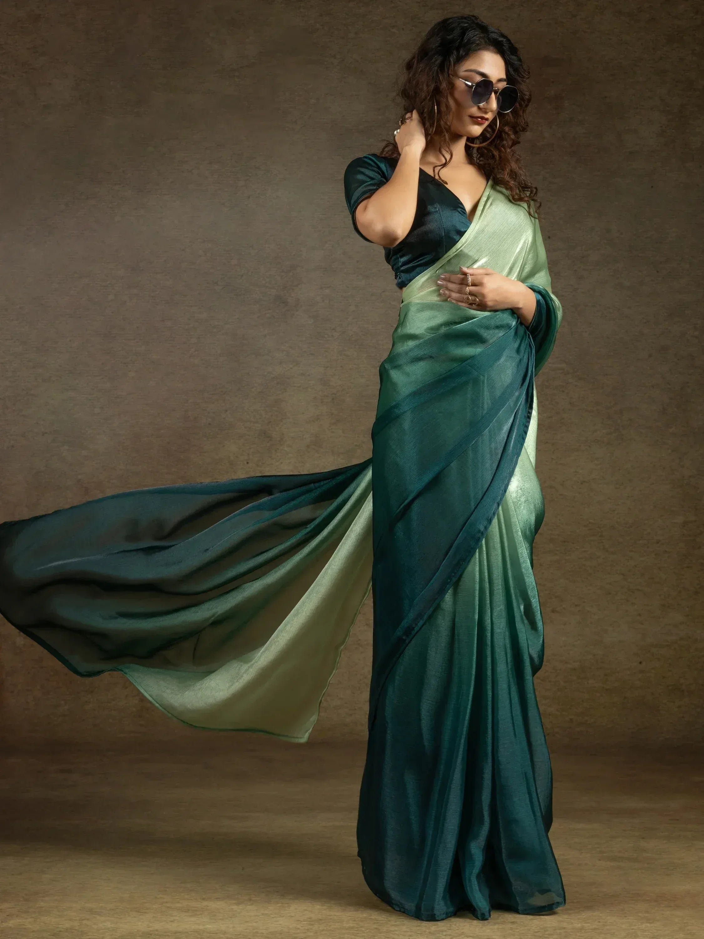 Woman in elegant green ombre saree with matching blouse, stylish ethnic wear for special occasions