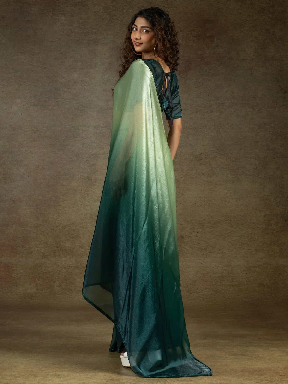 Woman in elegant green ombre ethnic gown with sheer overlay, perfect for Indian festive occasions