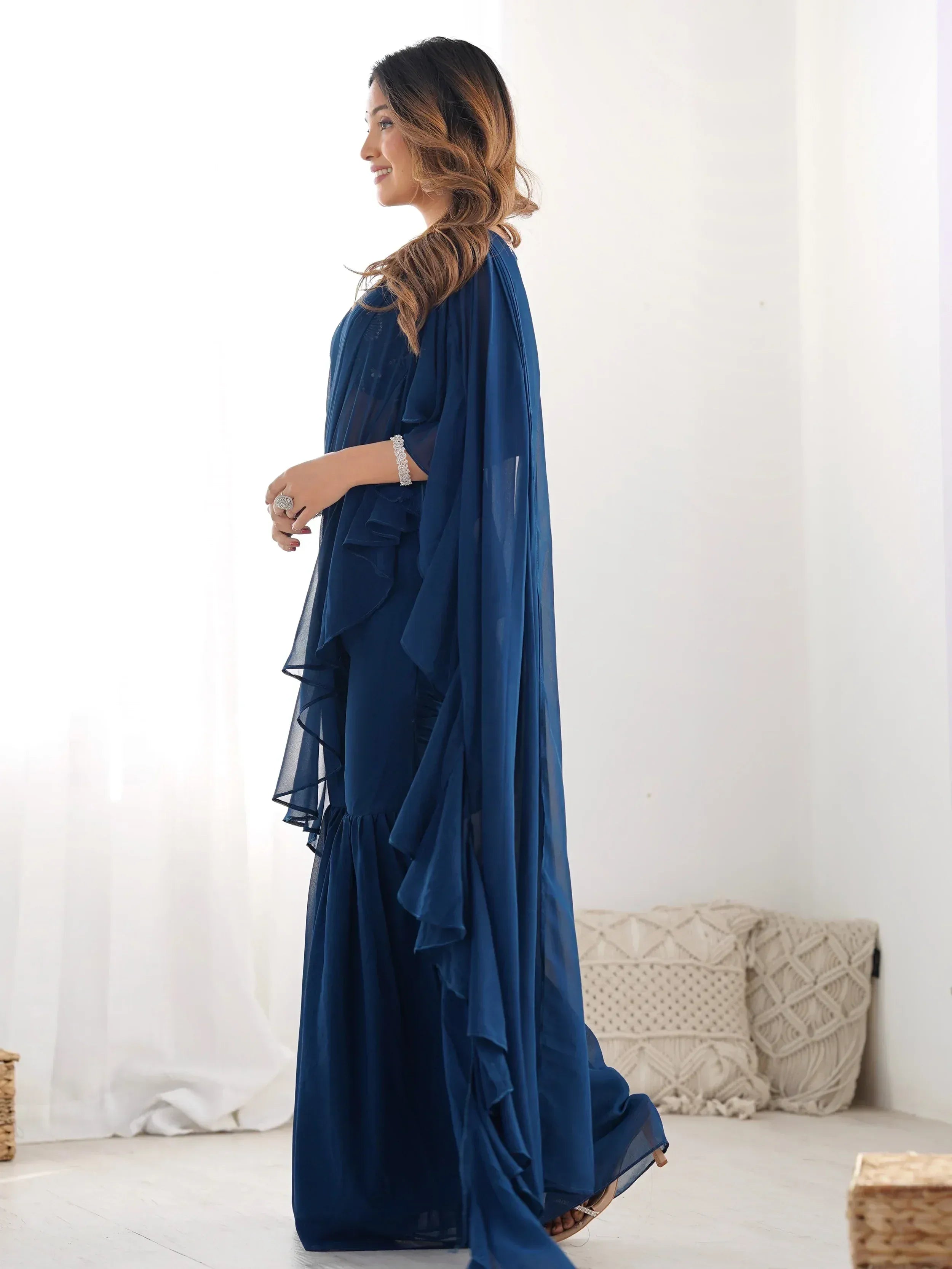 Elegant navy blue ethnic gown with ruffled layers and sheer cape, perfect for Indian occasions