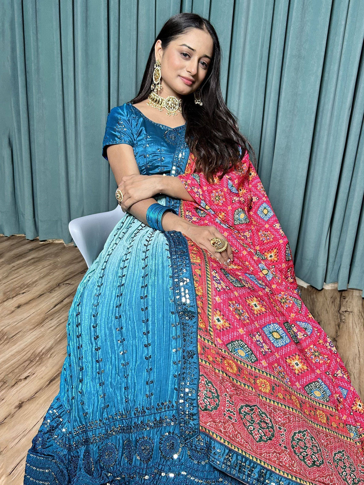Woman in blue embroidered lehenga choli with colorful printed dupatta, traditional Indian ethnic wear
