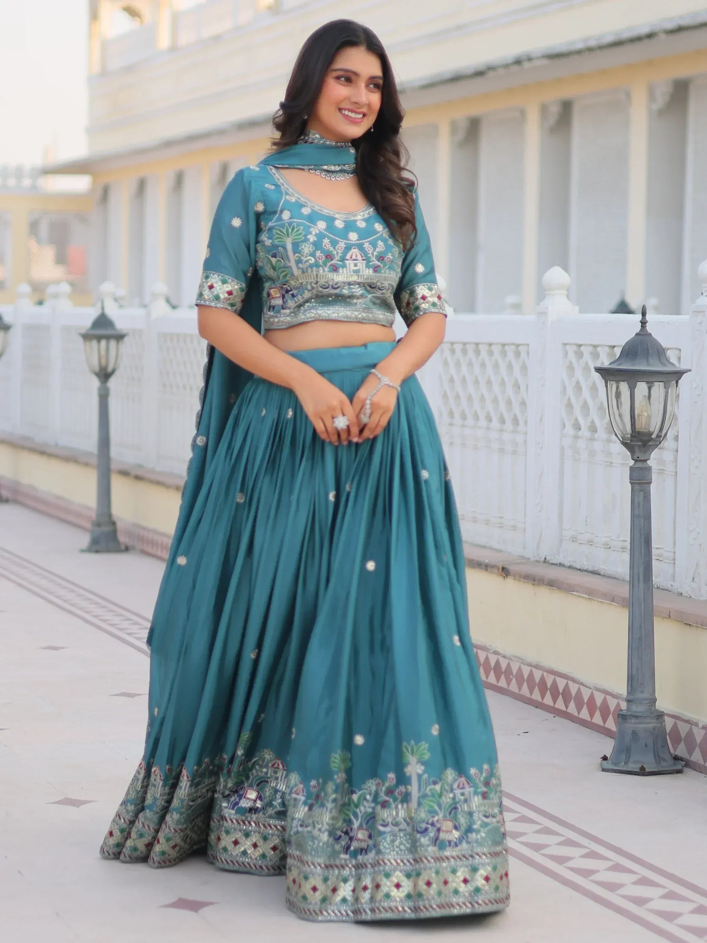 Teal embroidered lehenga choli with floral and elephant motifs, perfect for Indian ethnic wear occasions.