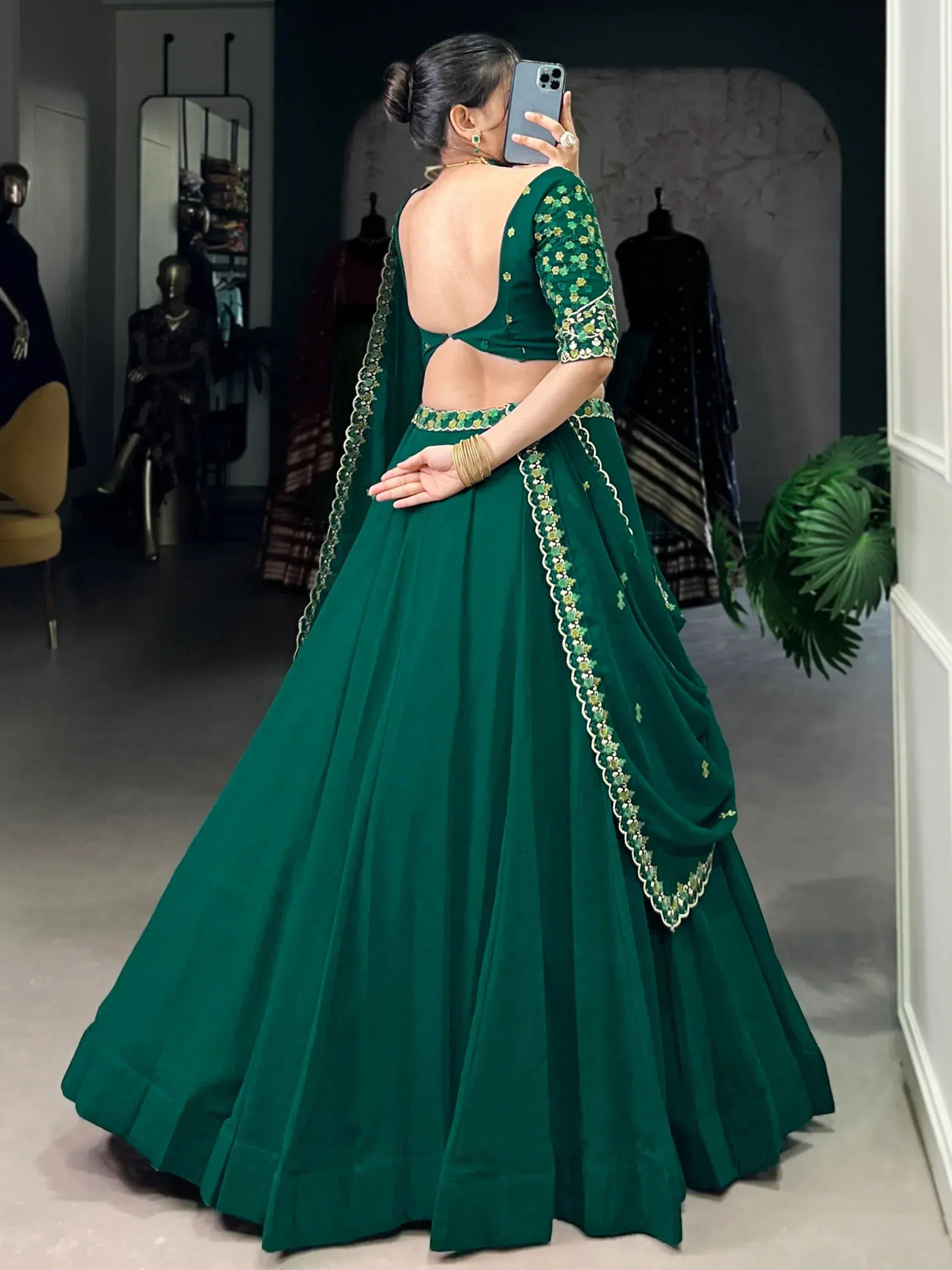 Emerald green designer lehenga choli with floral embroidery and open back, perfect for Indian ethnic wear.